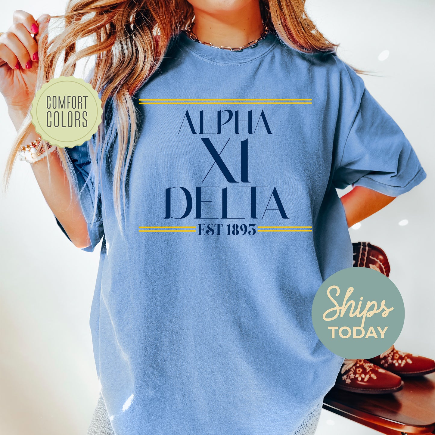 a woman wearing a blue shirt with the words alpha xi delta printed on it