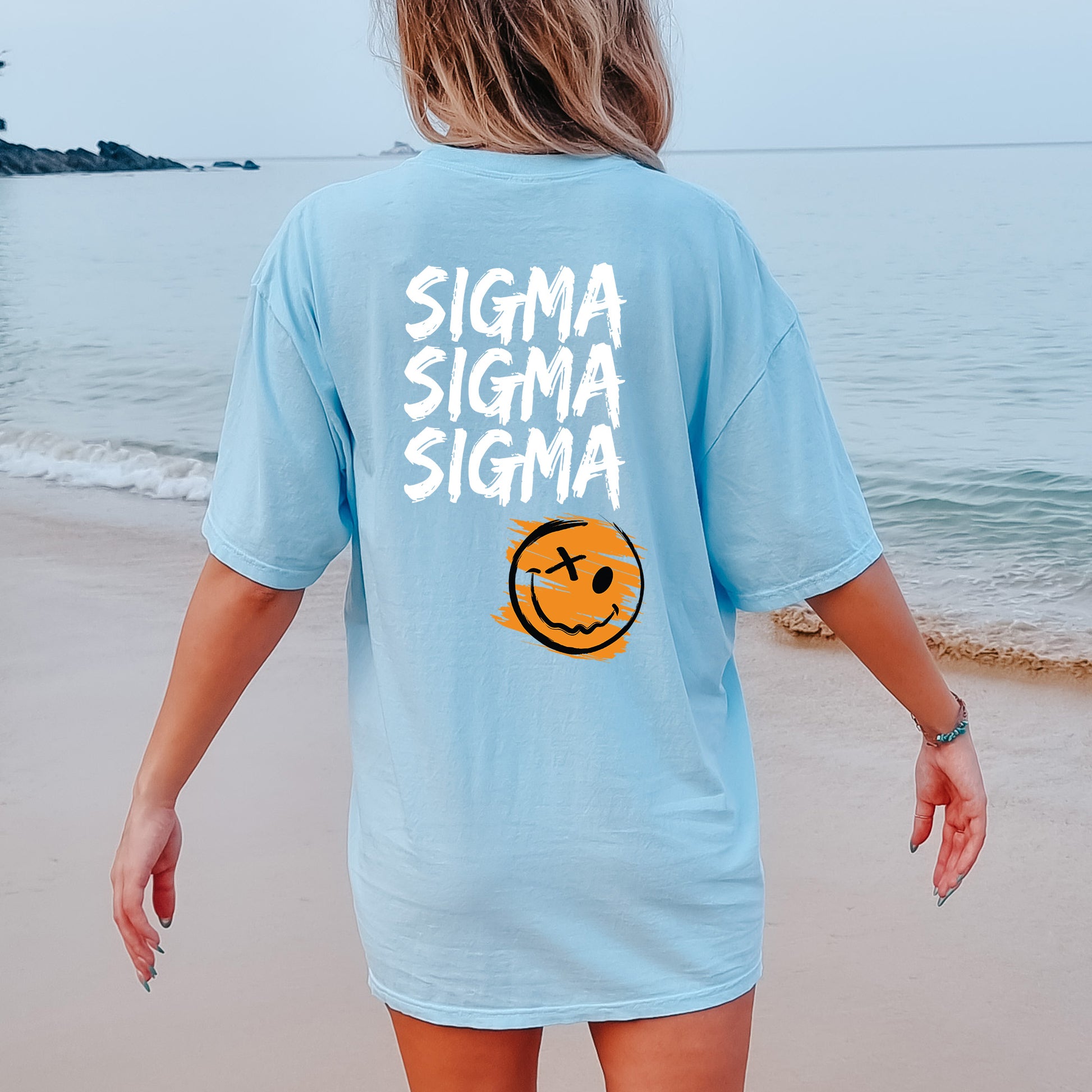 a woman walking on the beach with a smile on her shirt