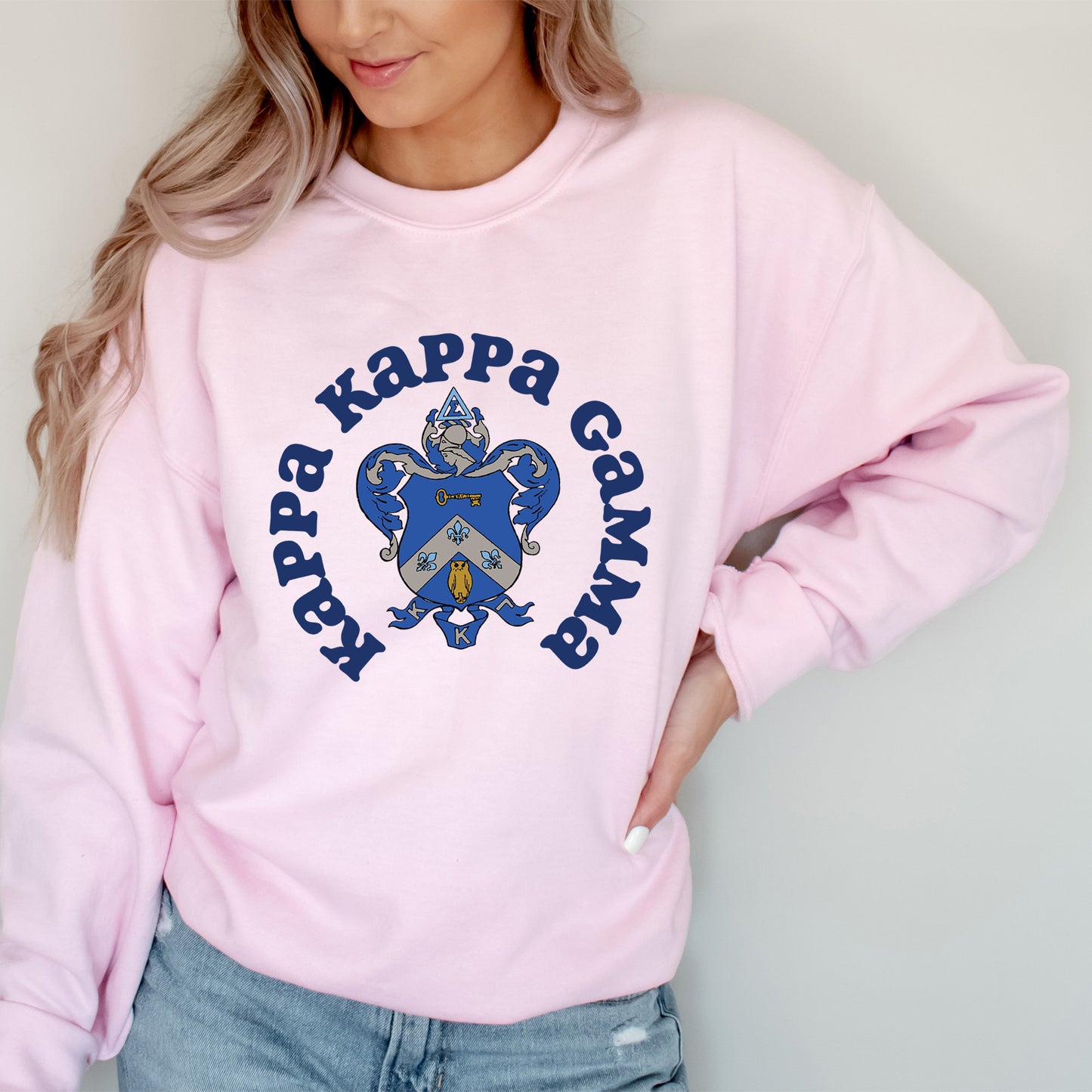 a woman wearing a pink sweatshirt with a blue and yellow heart on it