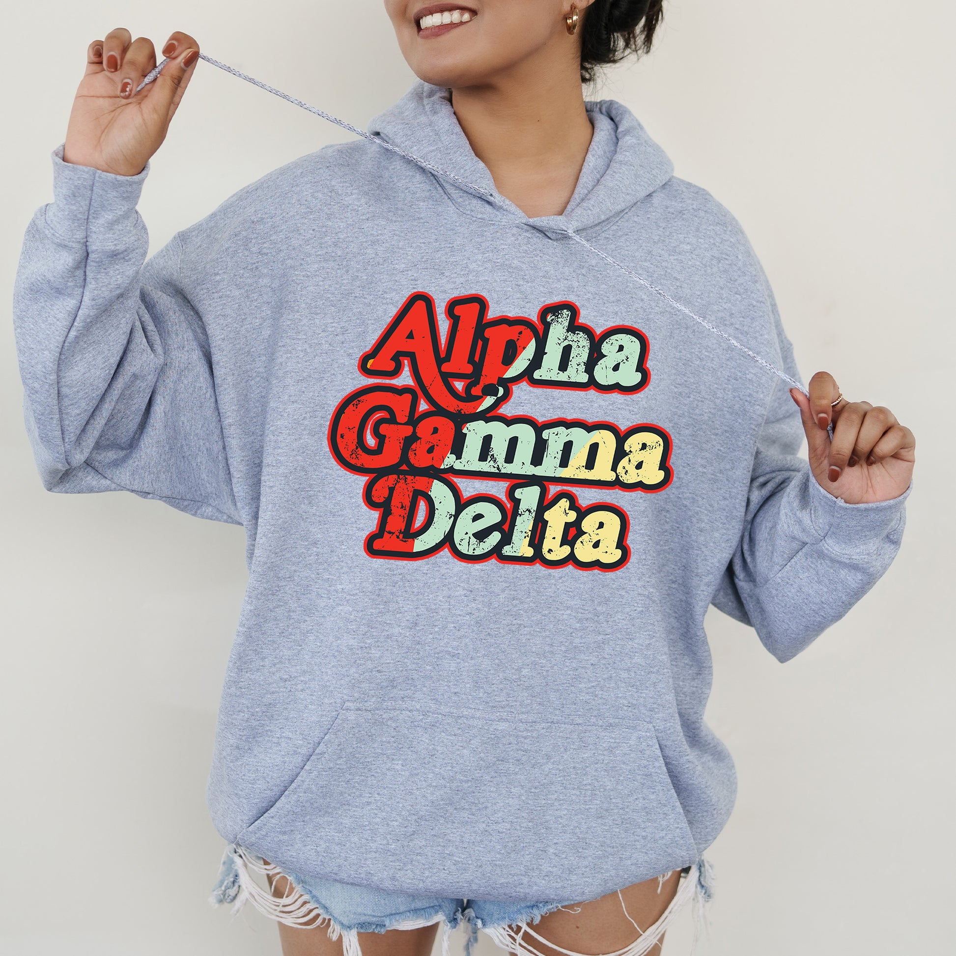 a woman wearing a blue sweatshirt with the words aloha gama delta on