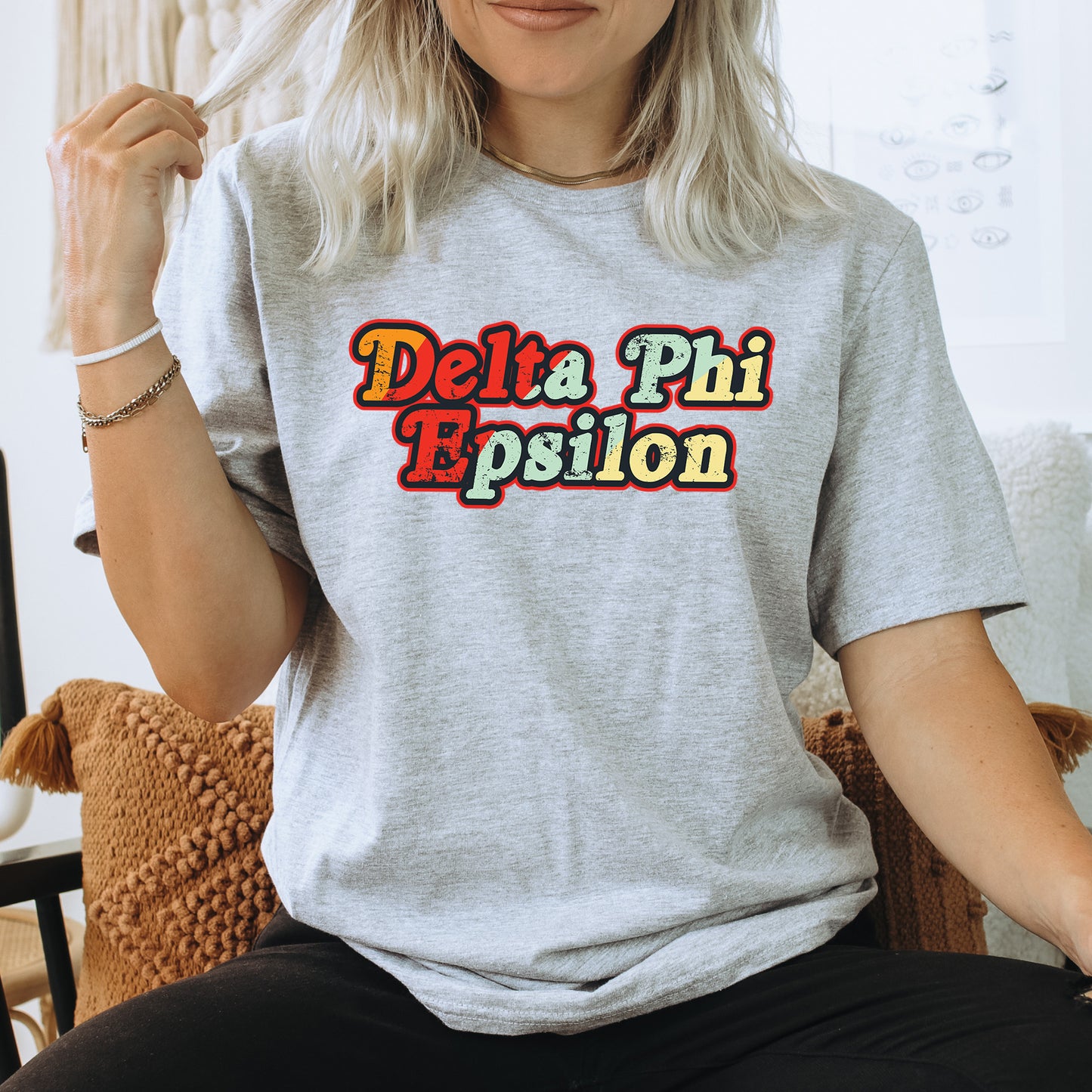 a woman sitting on a chair wearing a delta phi shirt