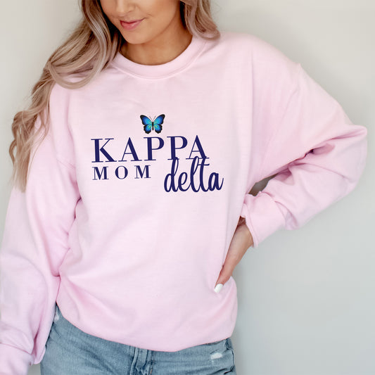 a woman wearing a pink sweatshirt that says kapp mom delta