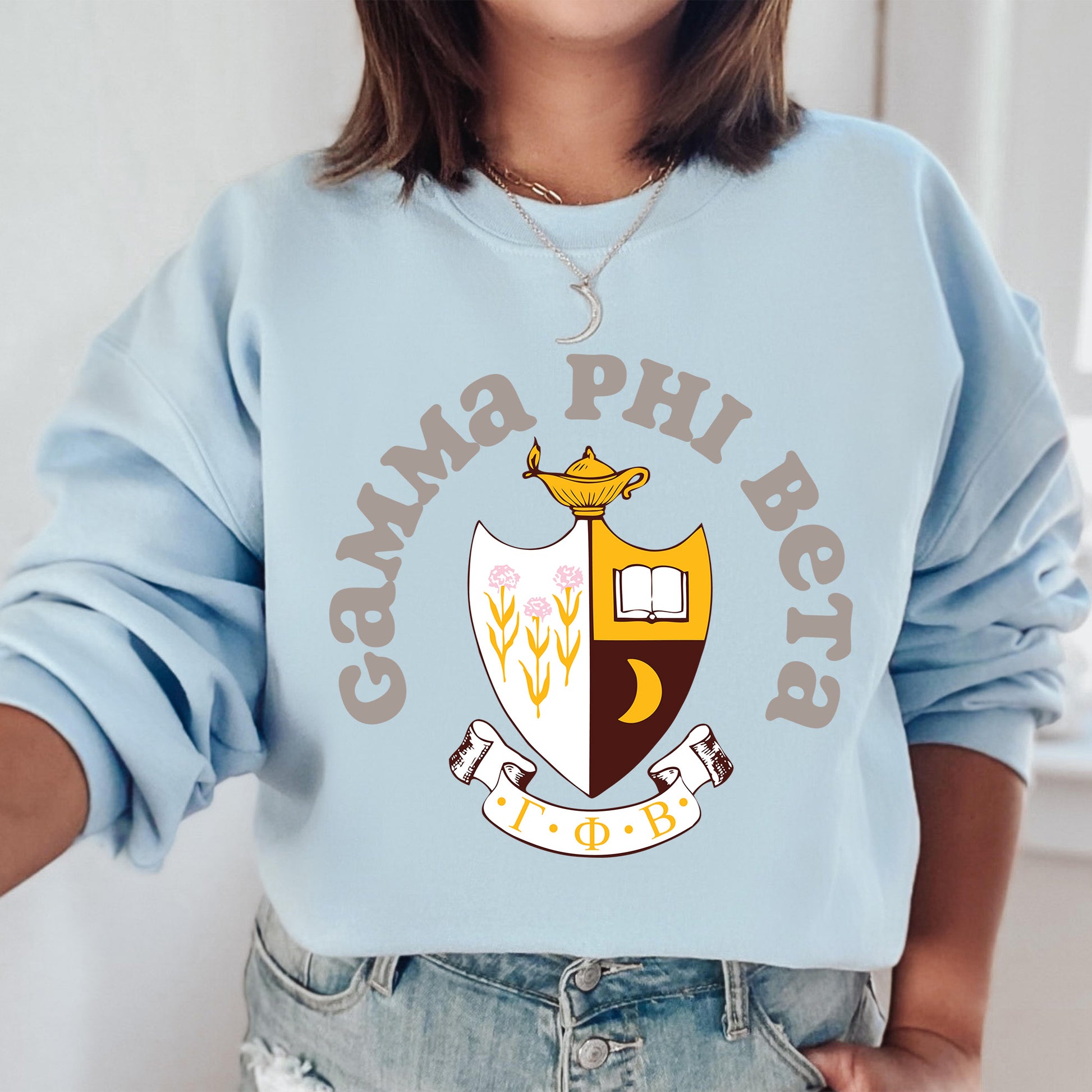 a woman wearing a blue sweatshirt with a crest on it