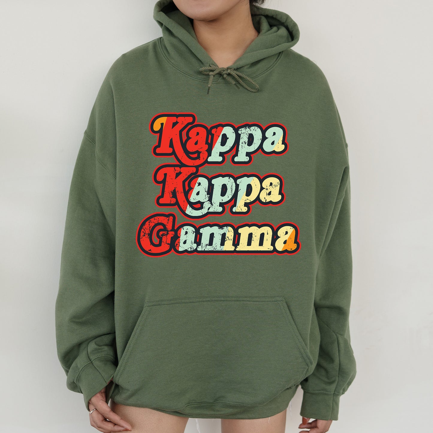 a woman wearing a green hoodie with the words kapp kapp gamma