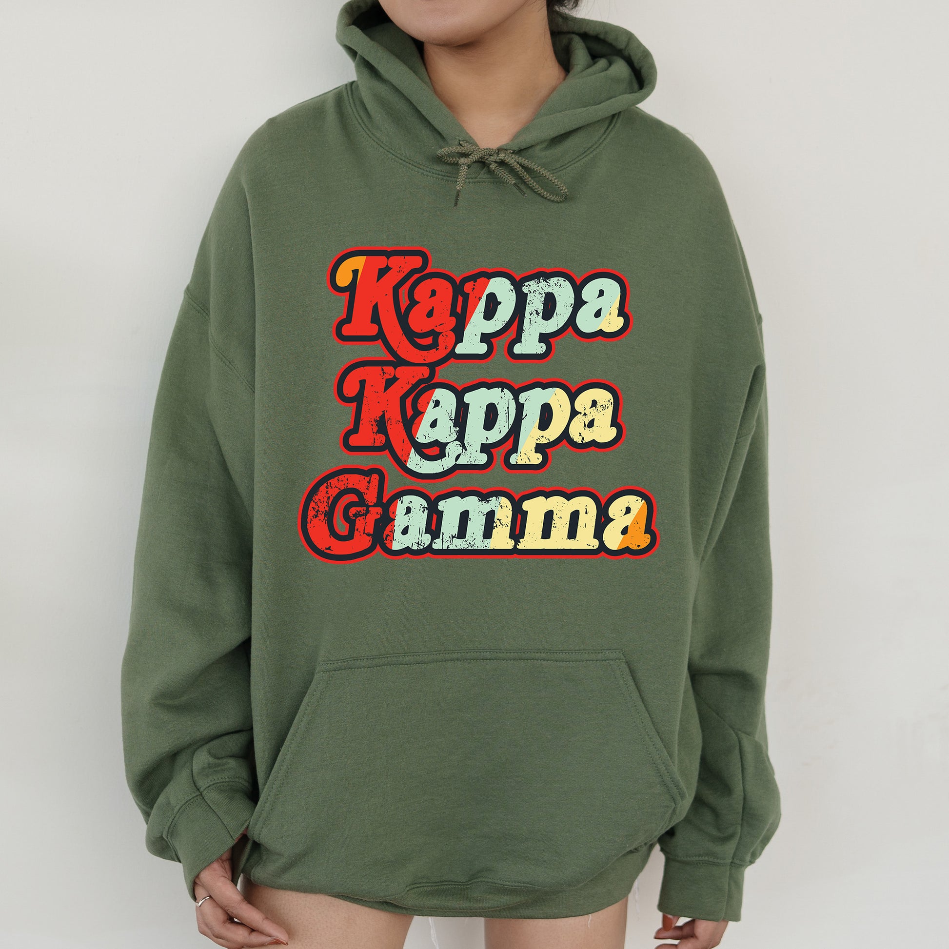 a woman wearing a green hoodie with the words kapp kapp gamma