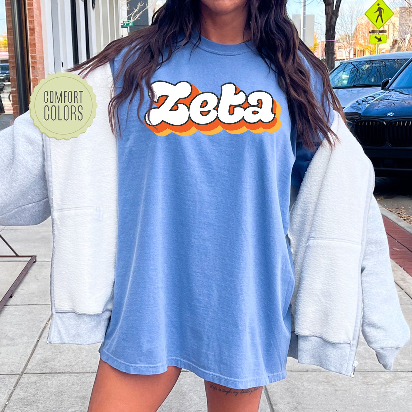 a woman standing on a sidewalk wearing a blue shirt