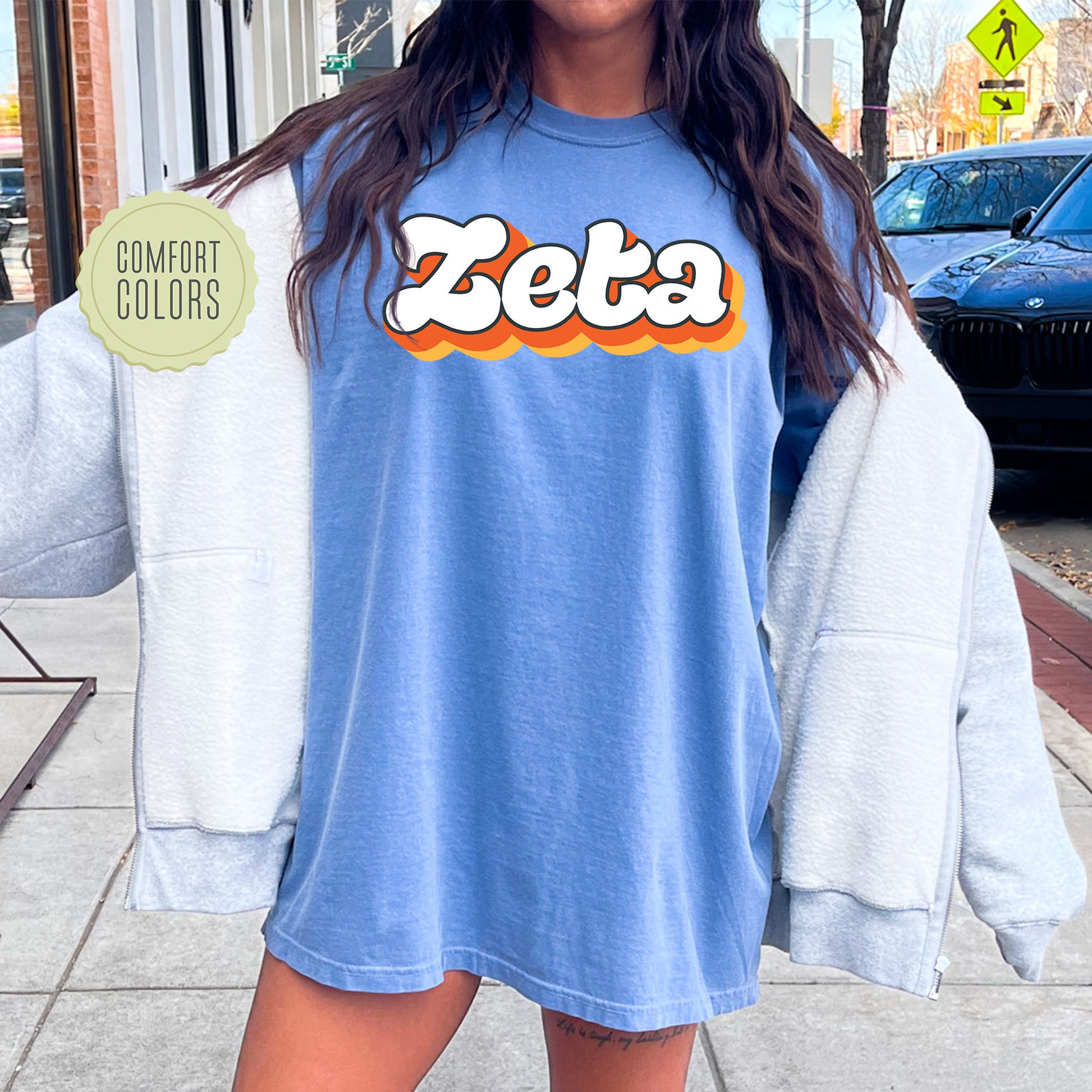 a woman standing on a sidewalk wearing a blue shirt