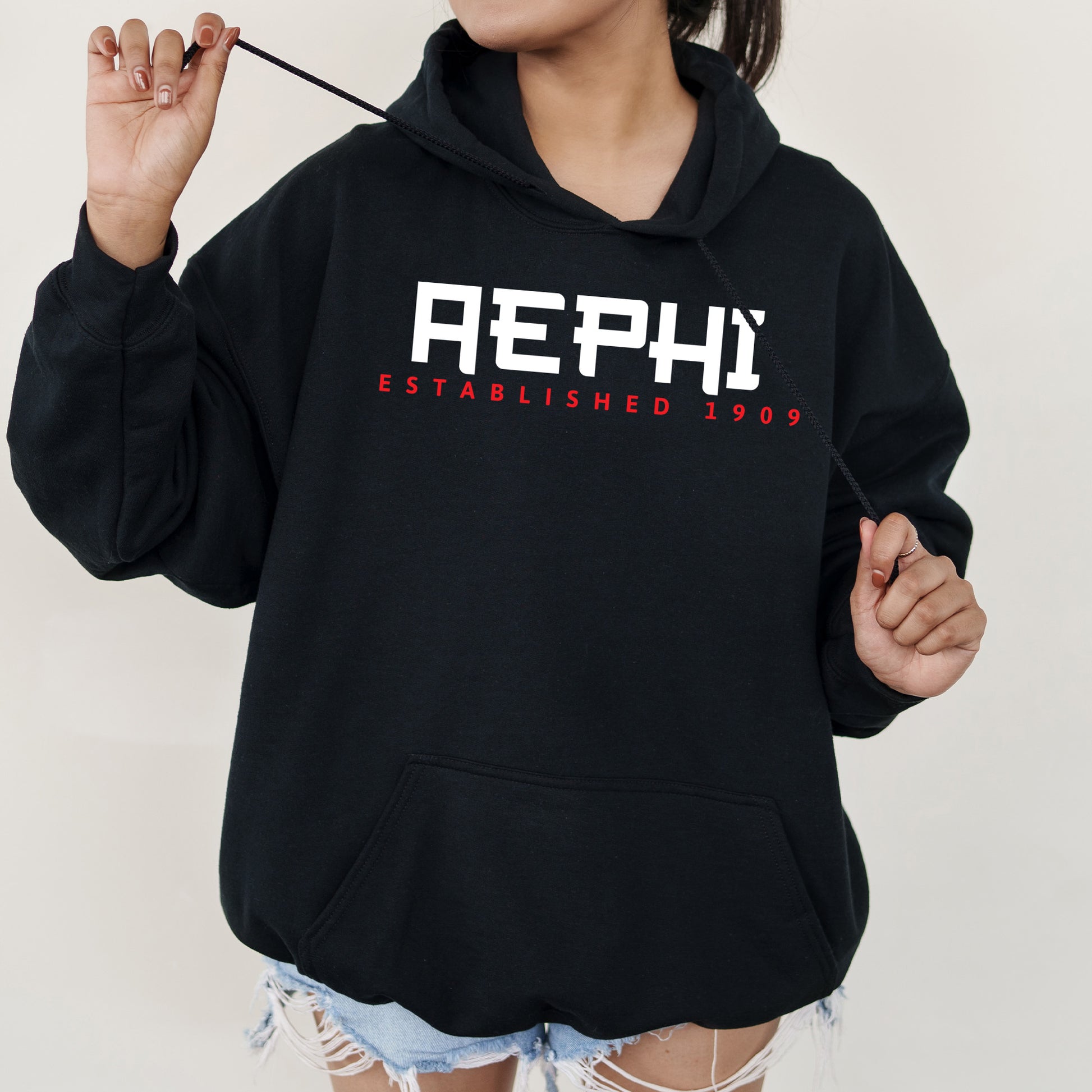 a woman in a black hoodie holding a black umbrella