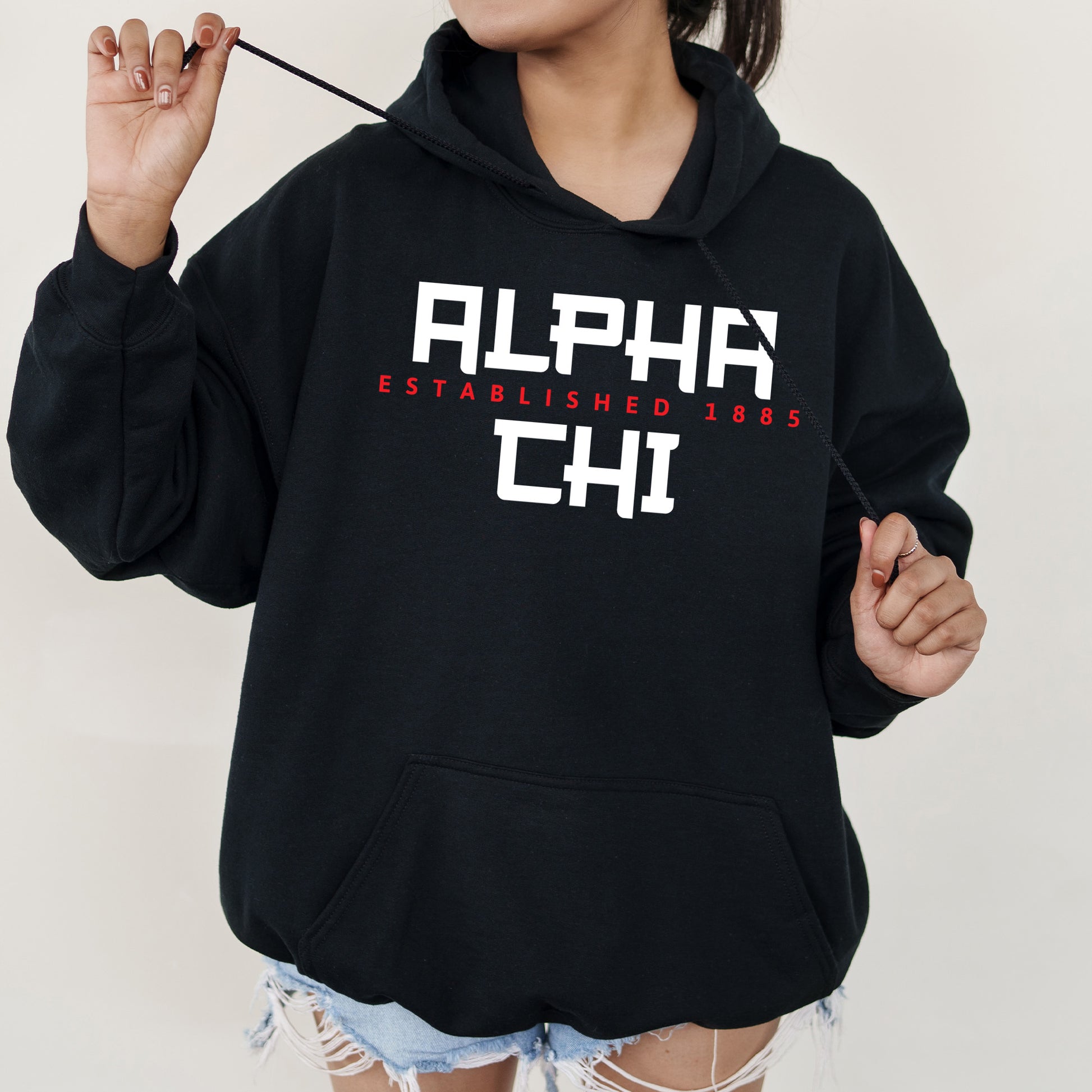 a girl in a black hoodie is holding a stick