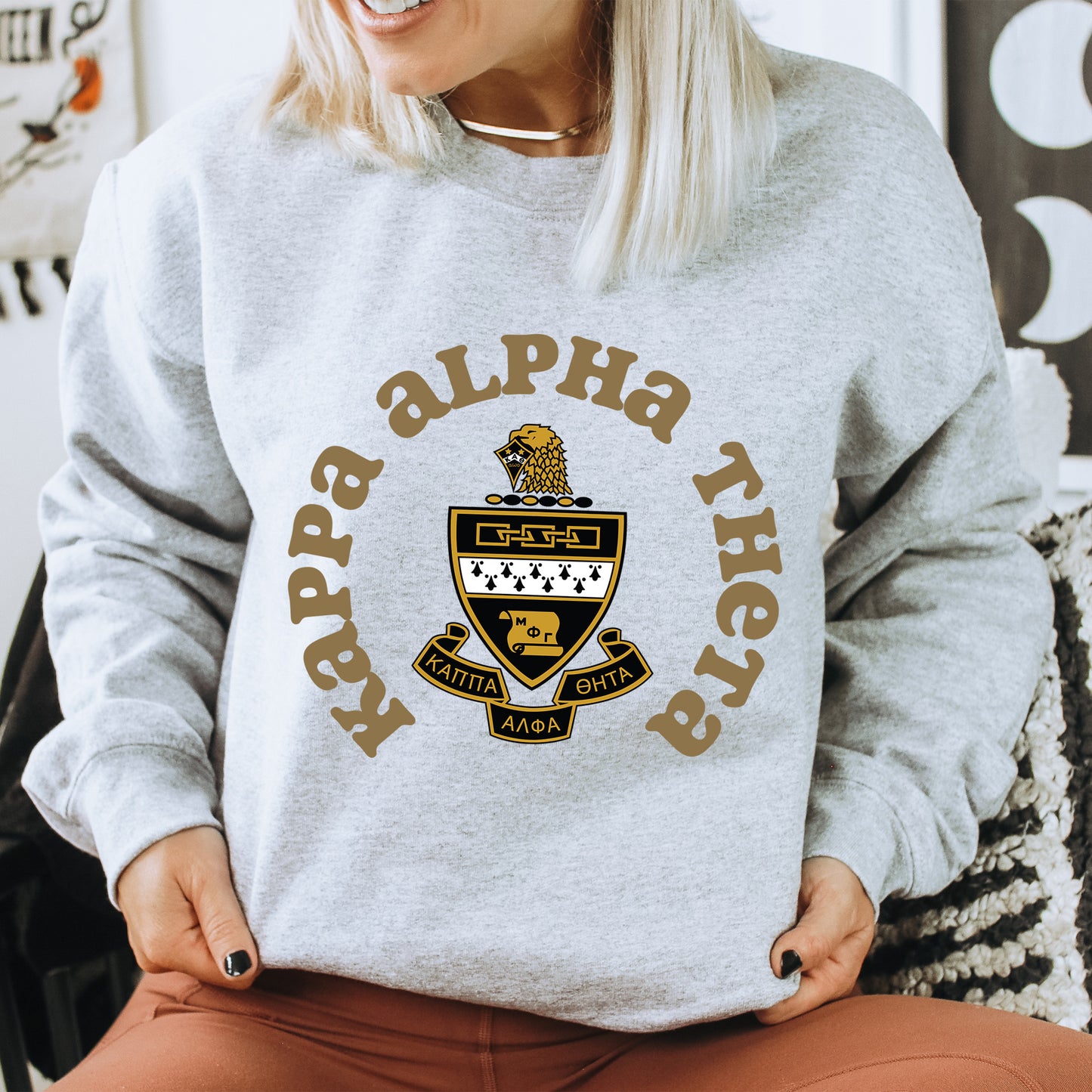 a woman sitting on a chair wearing a gray sweatshirt
