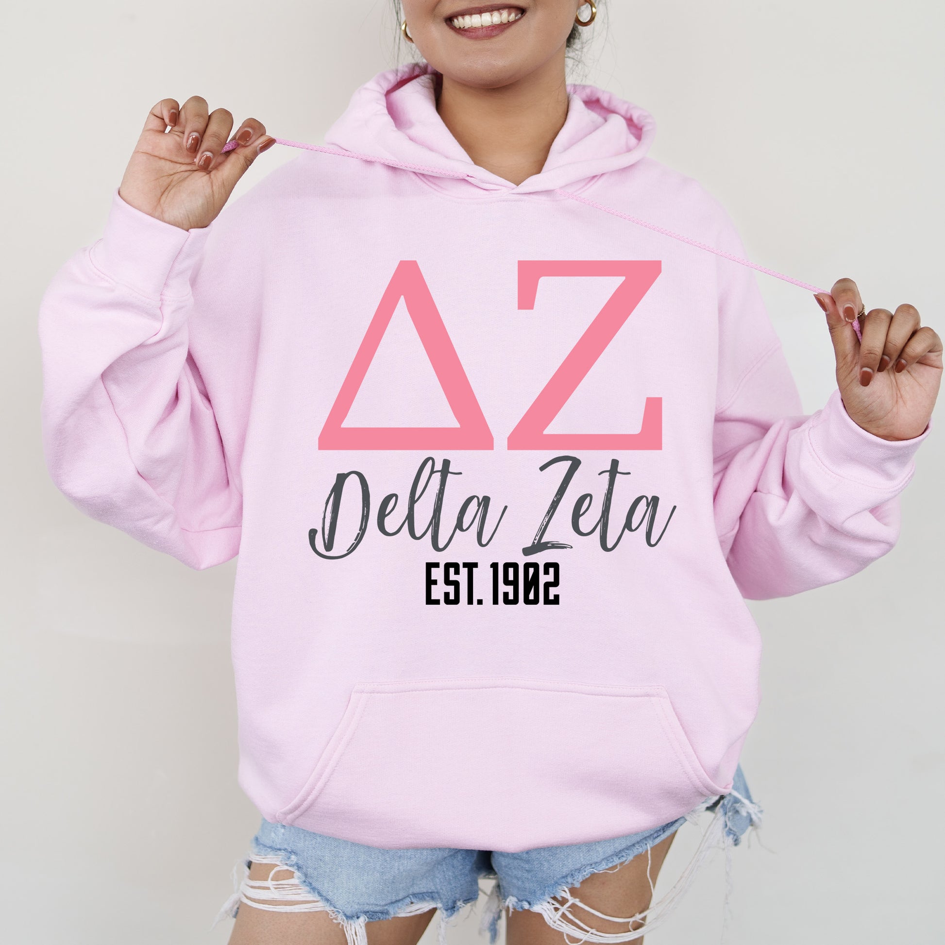 a woman wearing a pink delta delta hoodie