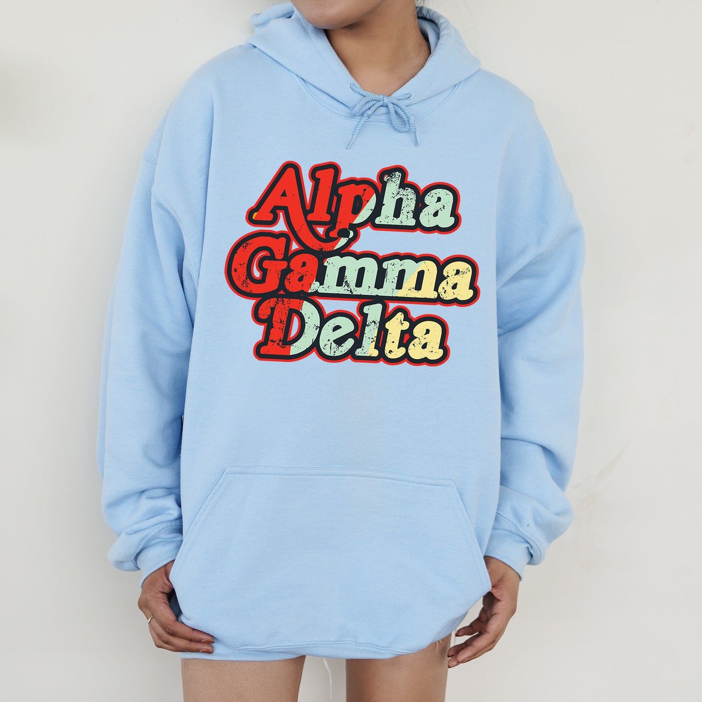 a person wearing a blue hoodie with the words aloha gumma delta