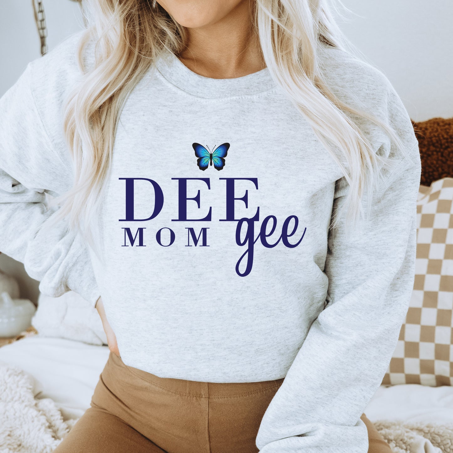 a woman wearing a sweatshirt that says deee mom gee
