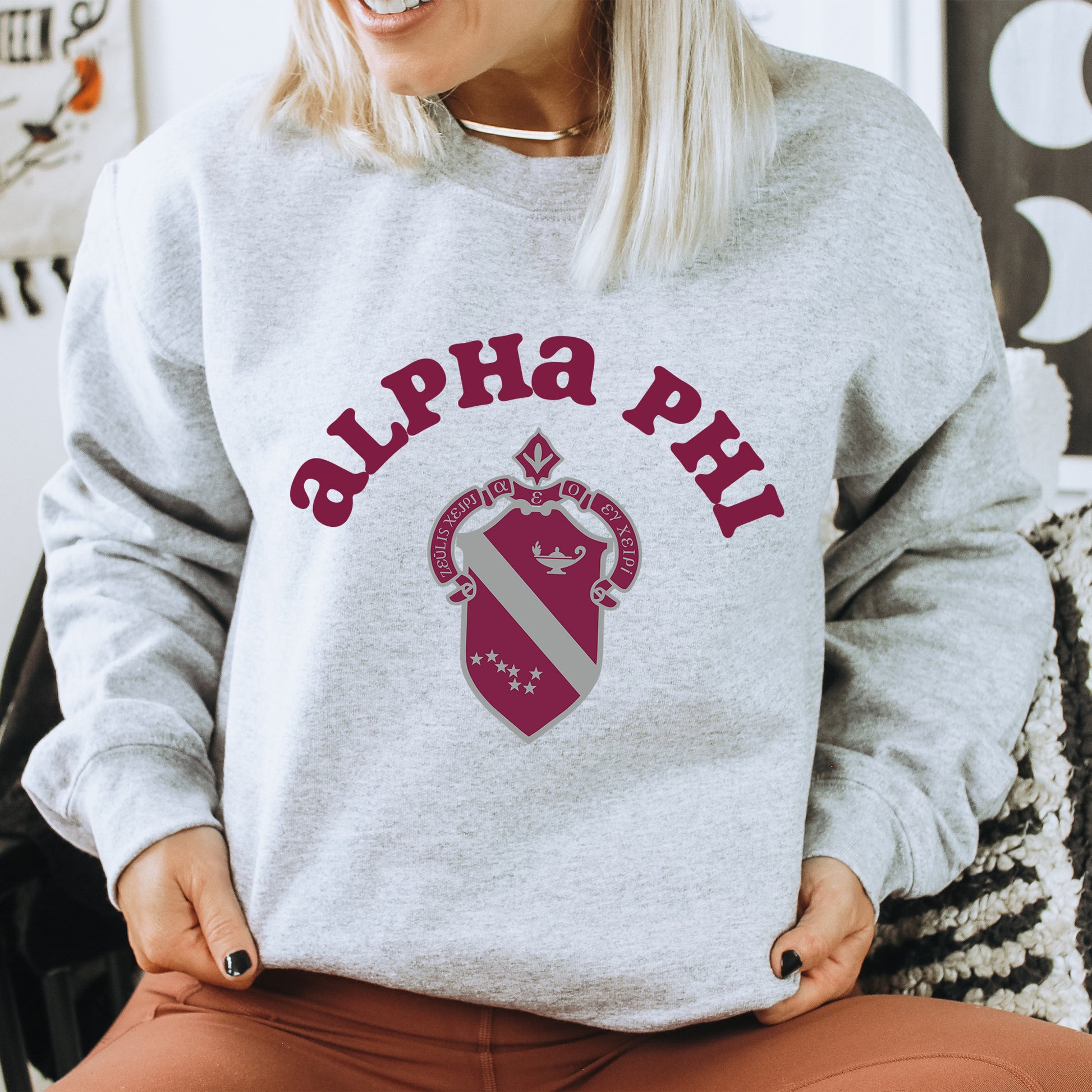 a woman sitting on a chair wearing a sweatshirt