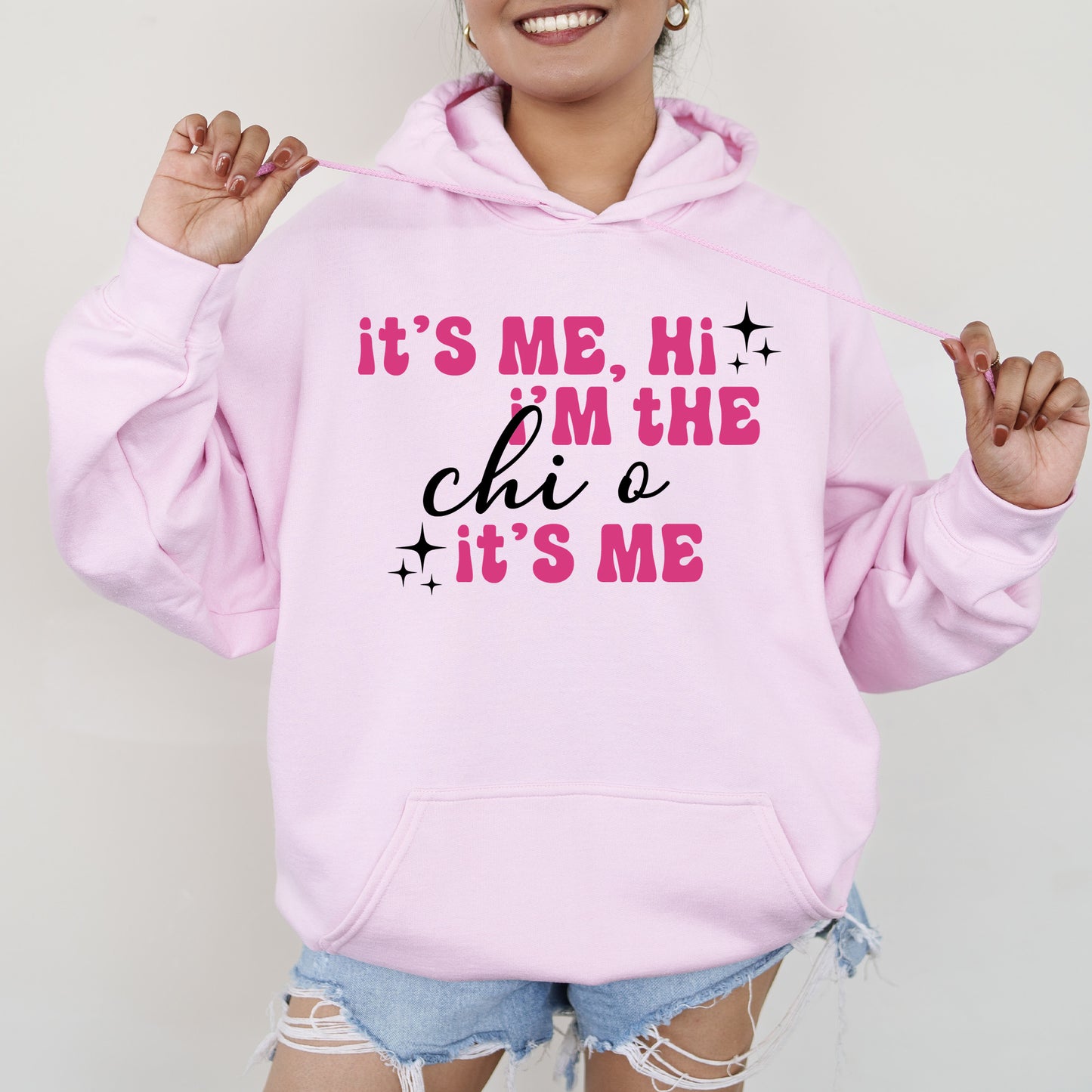 a woman wearing a pink hoodie that says it's me, he '
