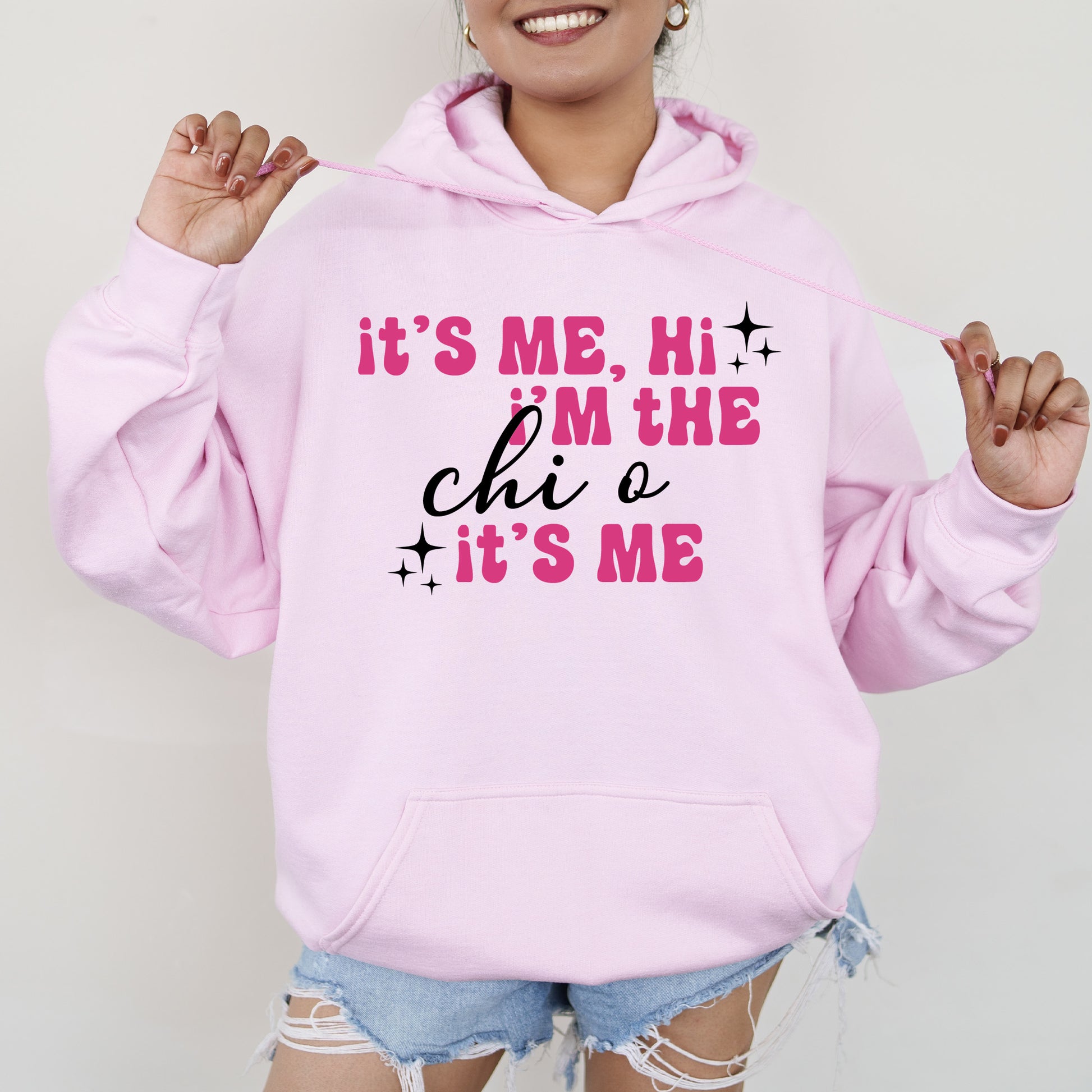 a woman wearing a pink hoodie that says it's me, he '