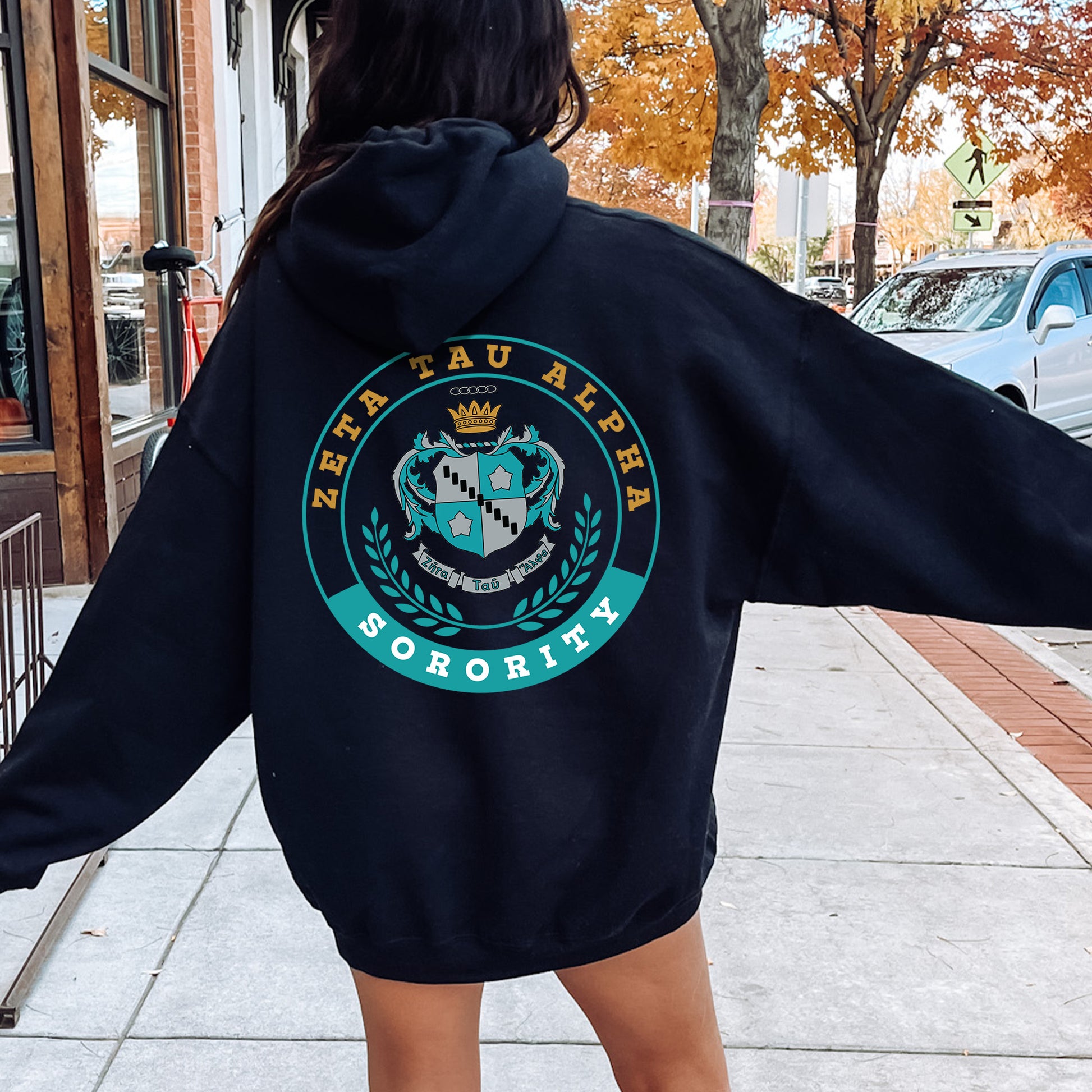 a woman in a black hoodie is walking down the street