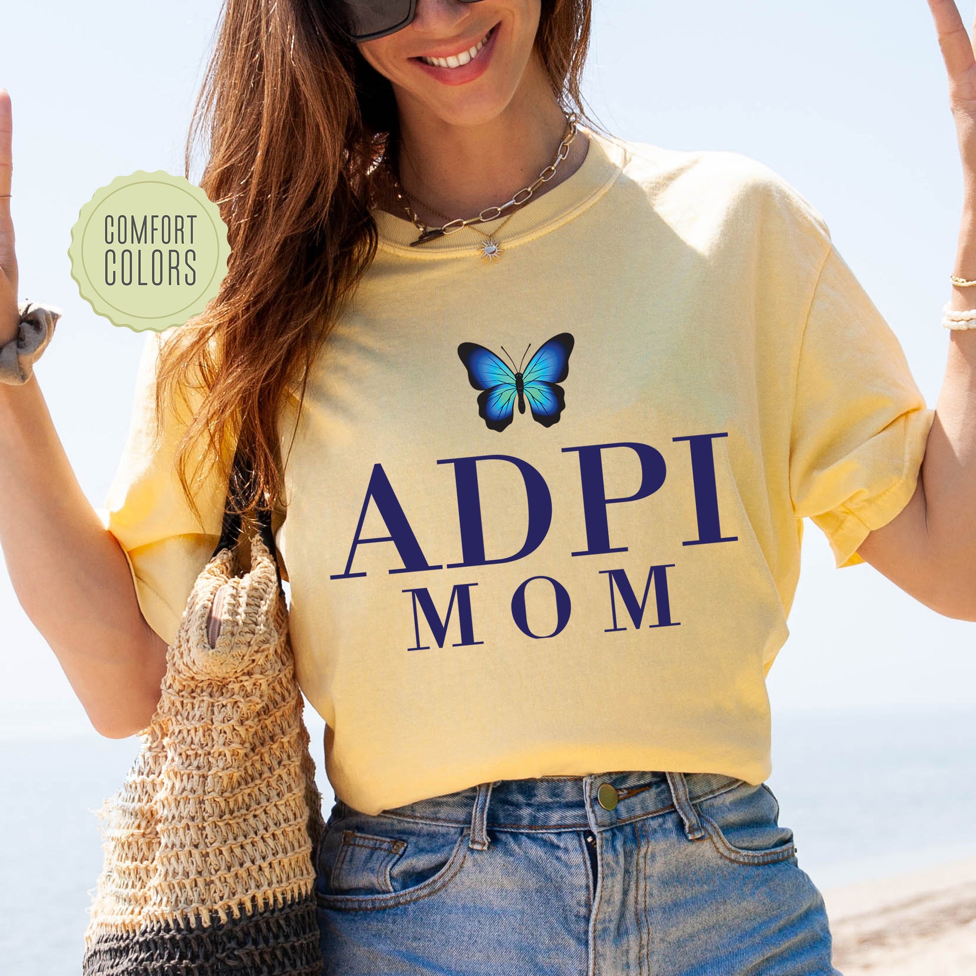 a woman wearing a yellow shirt with a butterfly on it