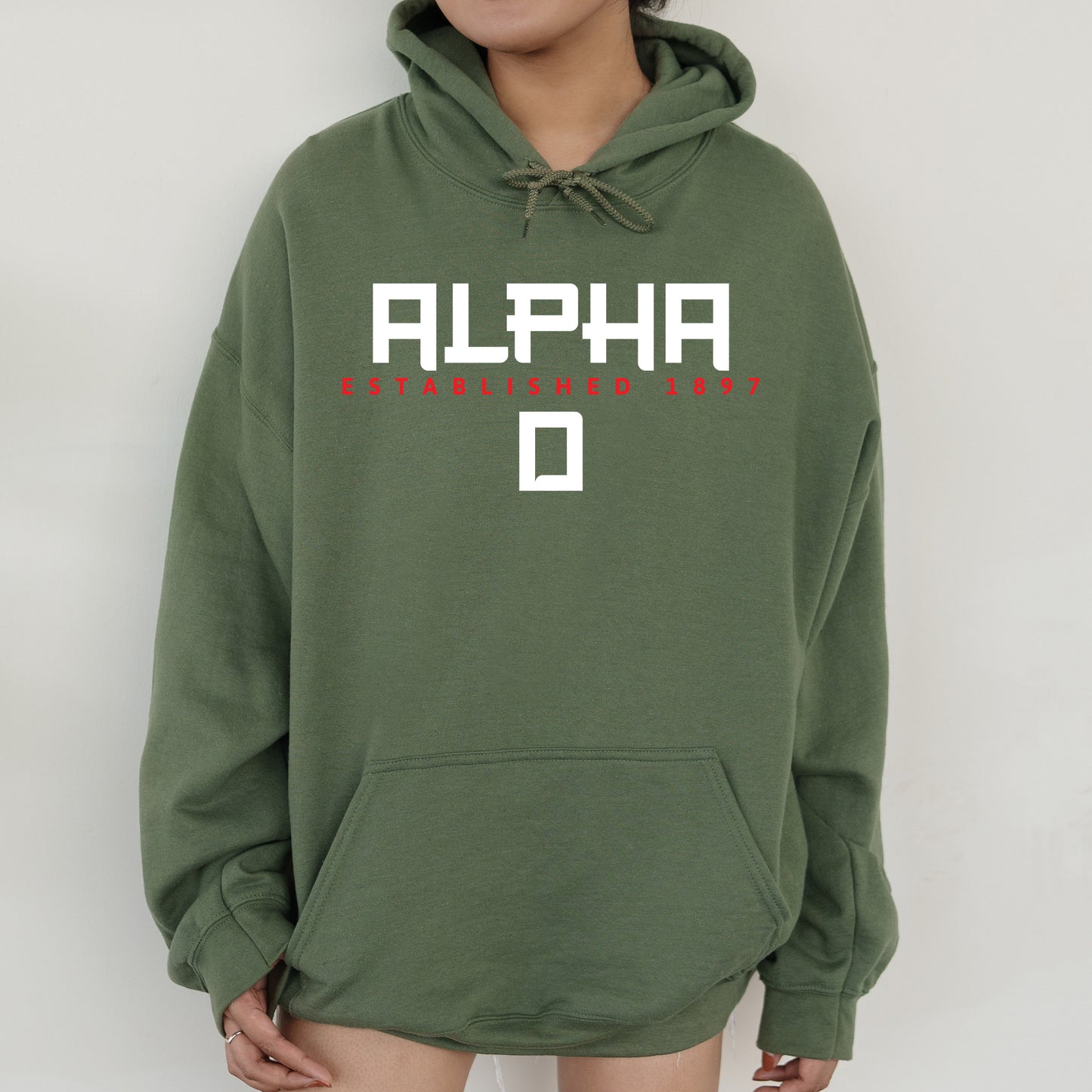 a person wearing a green hoodie with the word alphi on it