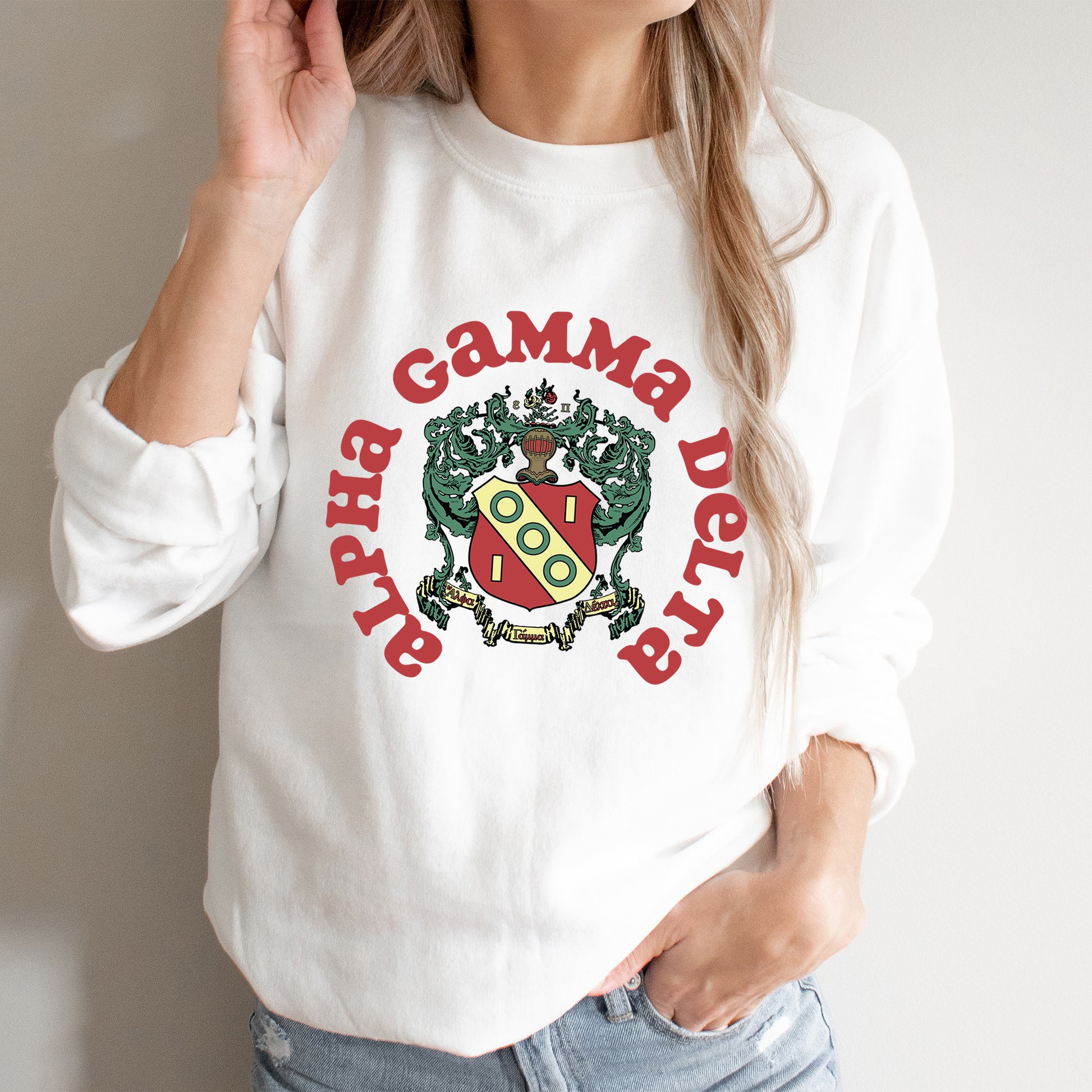 a woman wearing a white sweatshirt with a red and green logo