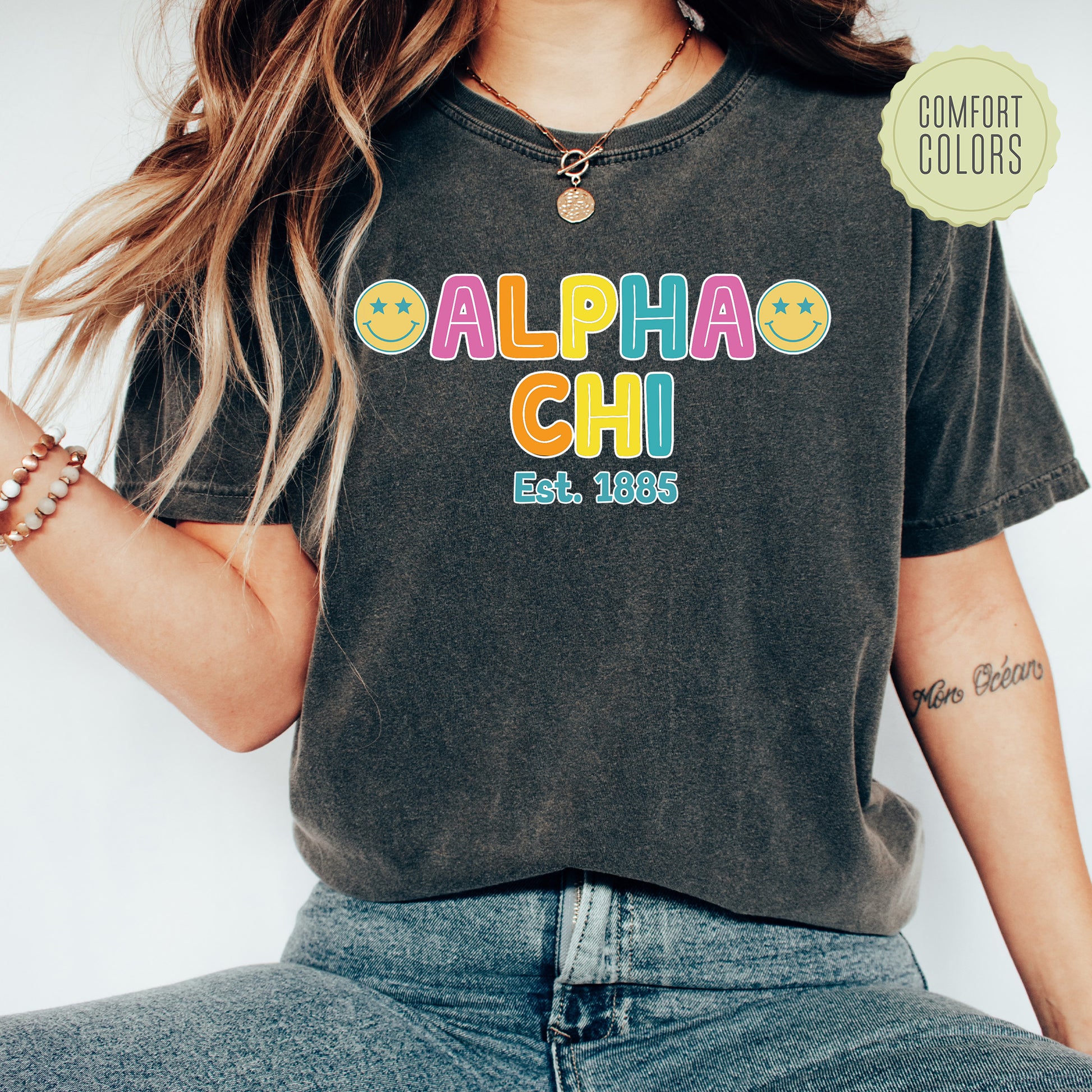 a woman wearing a black shirt with the word alpha chi on it