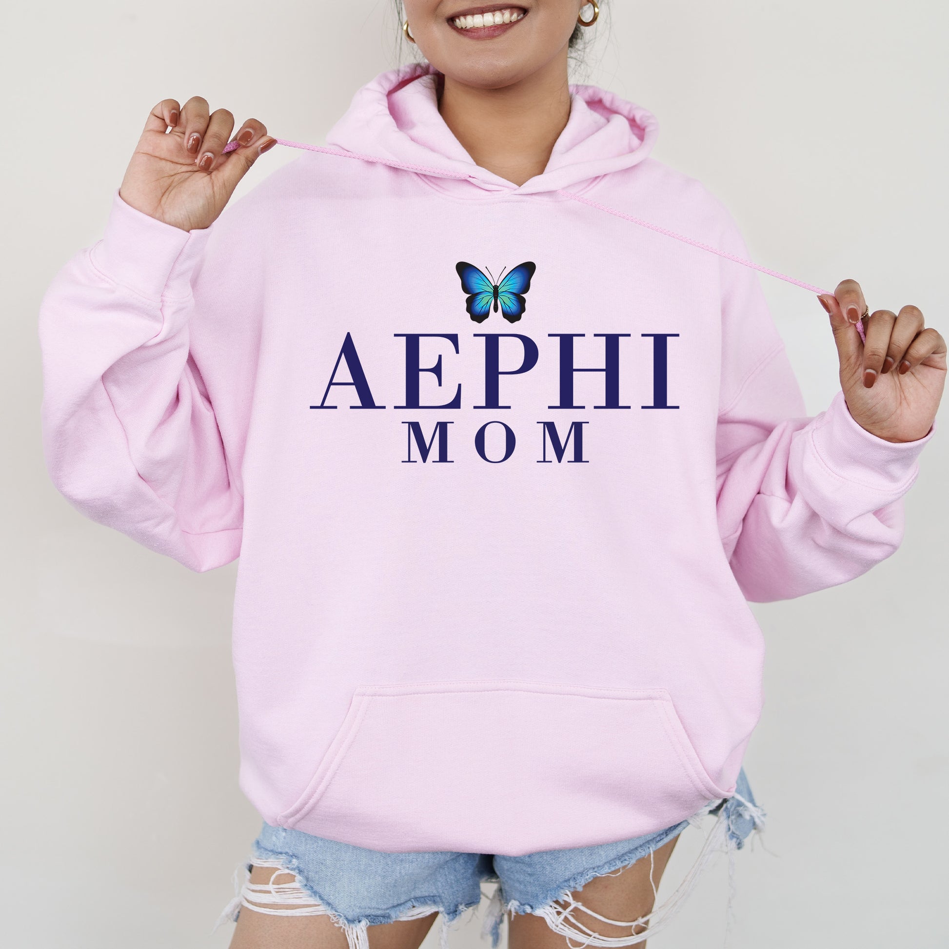 a woman wearing a pink hoodie with a butterfly on it