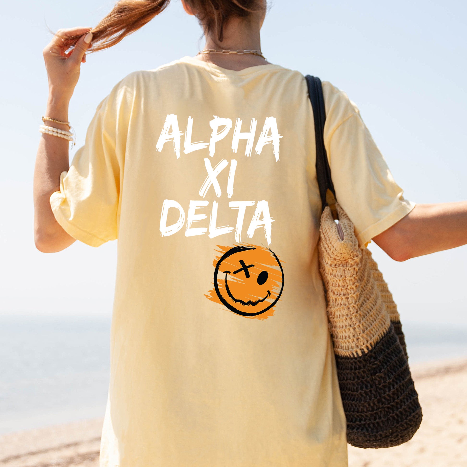 a woman walking on the beach with a smile on her shirt