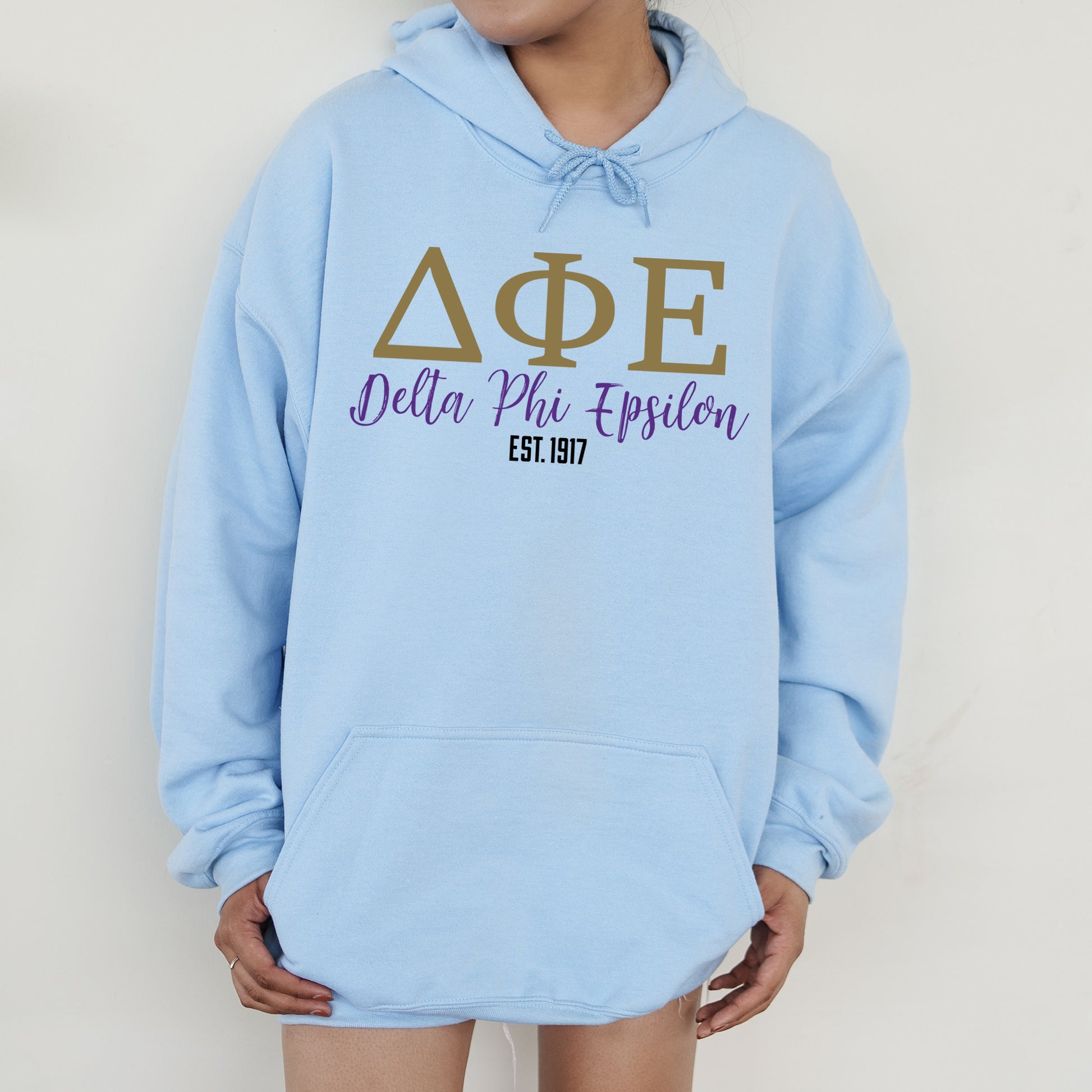 a person wearing a blue hoodie with greek letters on it