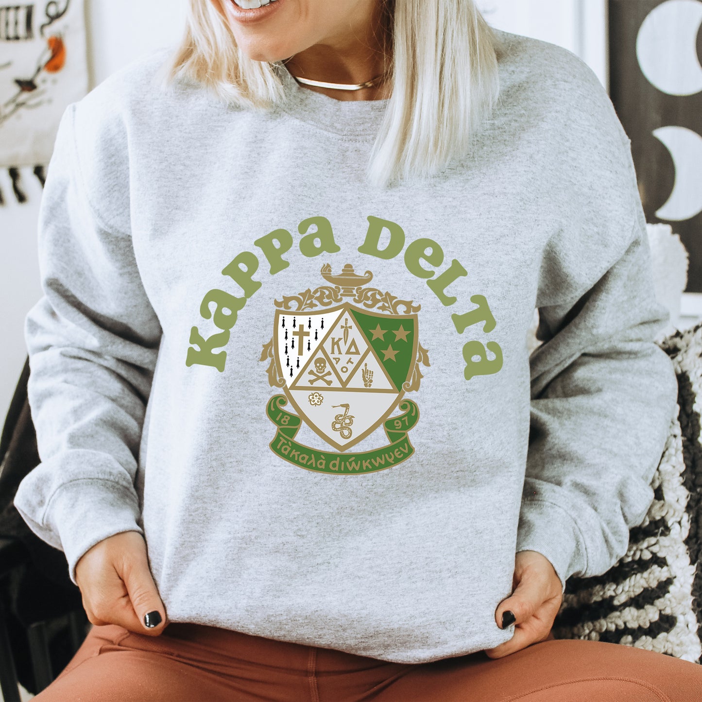 a woman sitting on a chair wearing a grey sweatshirt