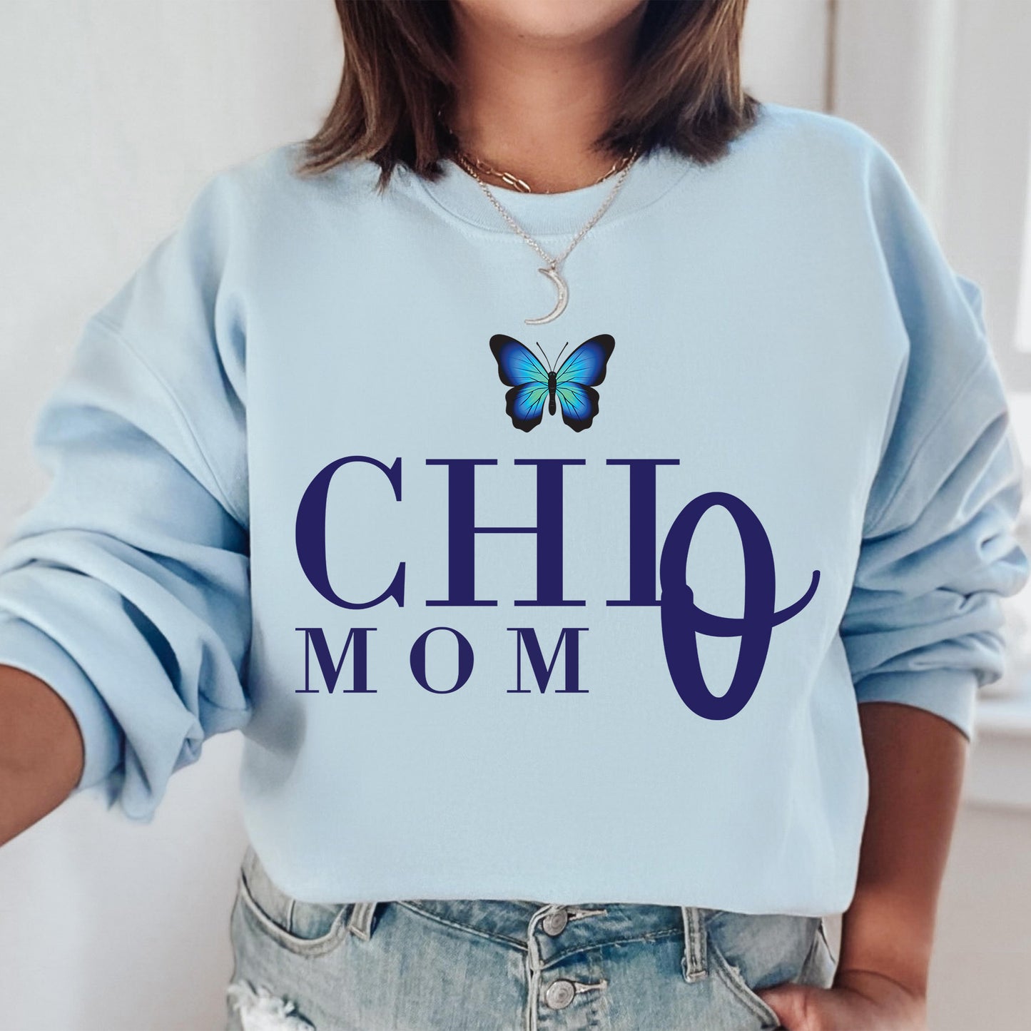 a woman wearing a blue sweatshirt with a butterfly on it