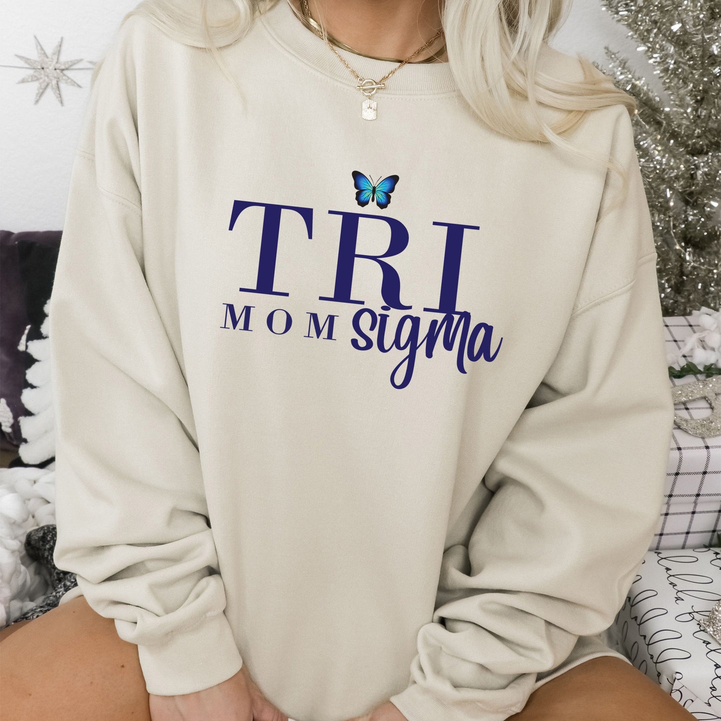a woman sitting on a bed wearing a sweatshirt