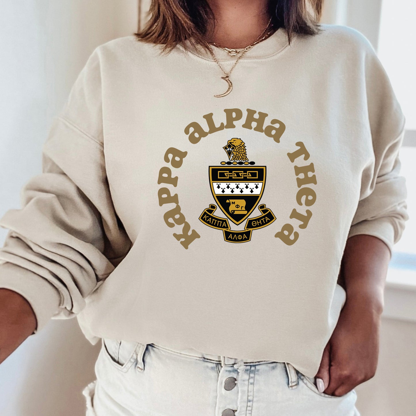 a woman wearing a white sweatshirt with a black and gold logo on it
