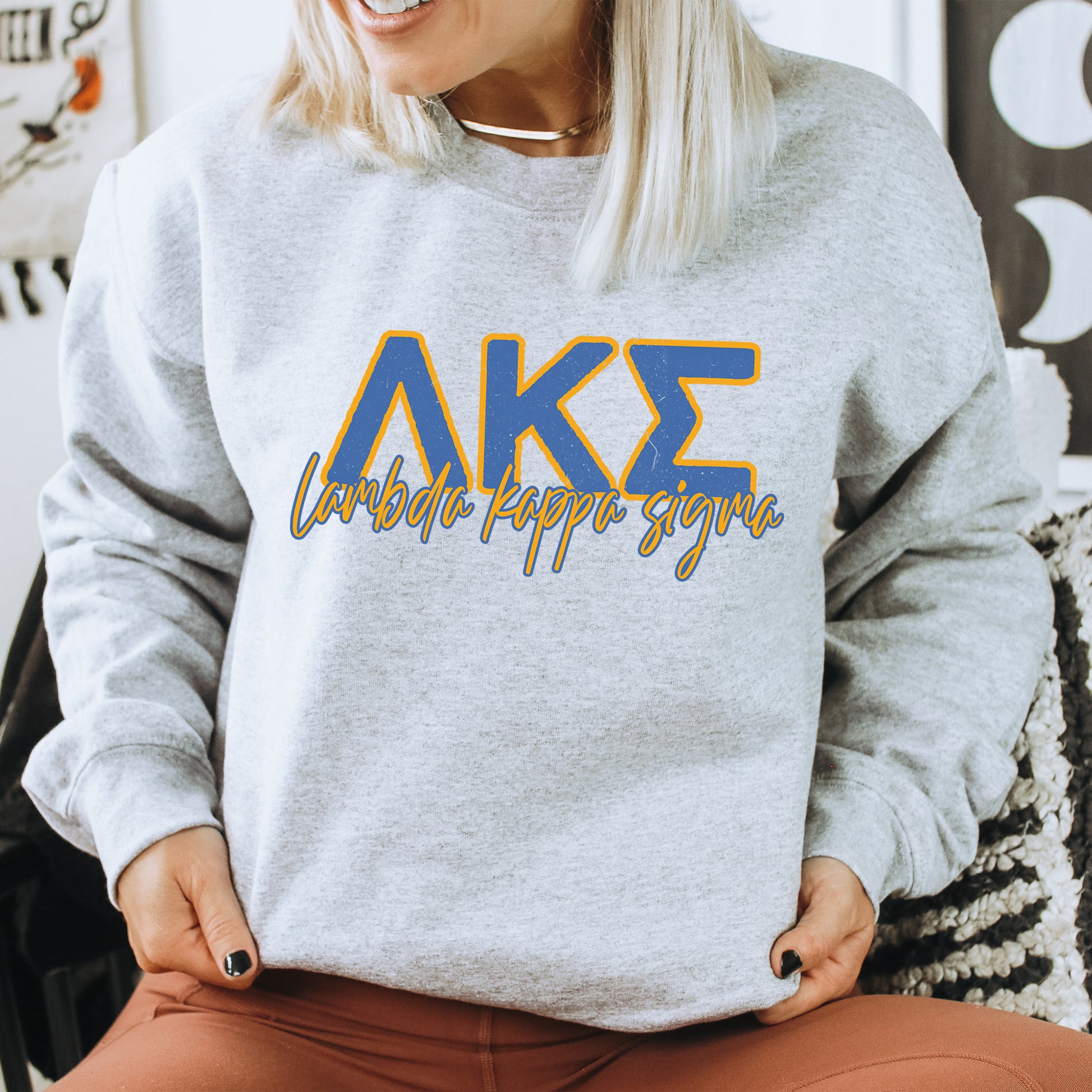 a woman sitting on a chair wearing a grey sweatshirt