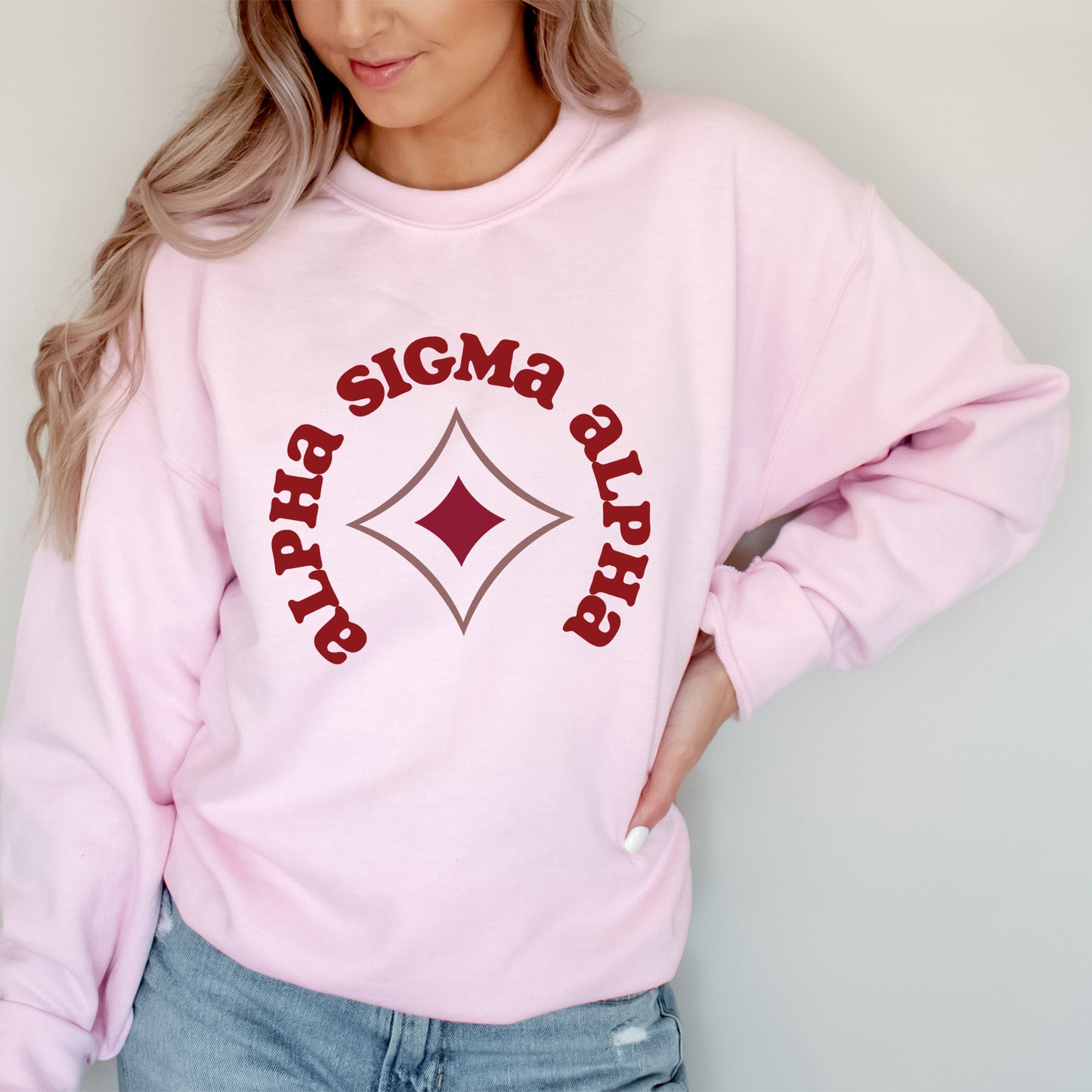 a woman wearing a pink sweater with a diamond on it
