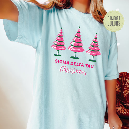 a woman wearing a blue tshirt with pink trees on it