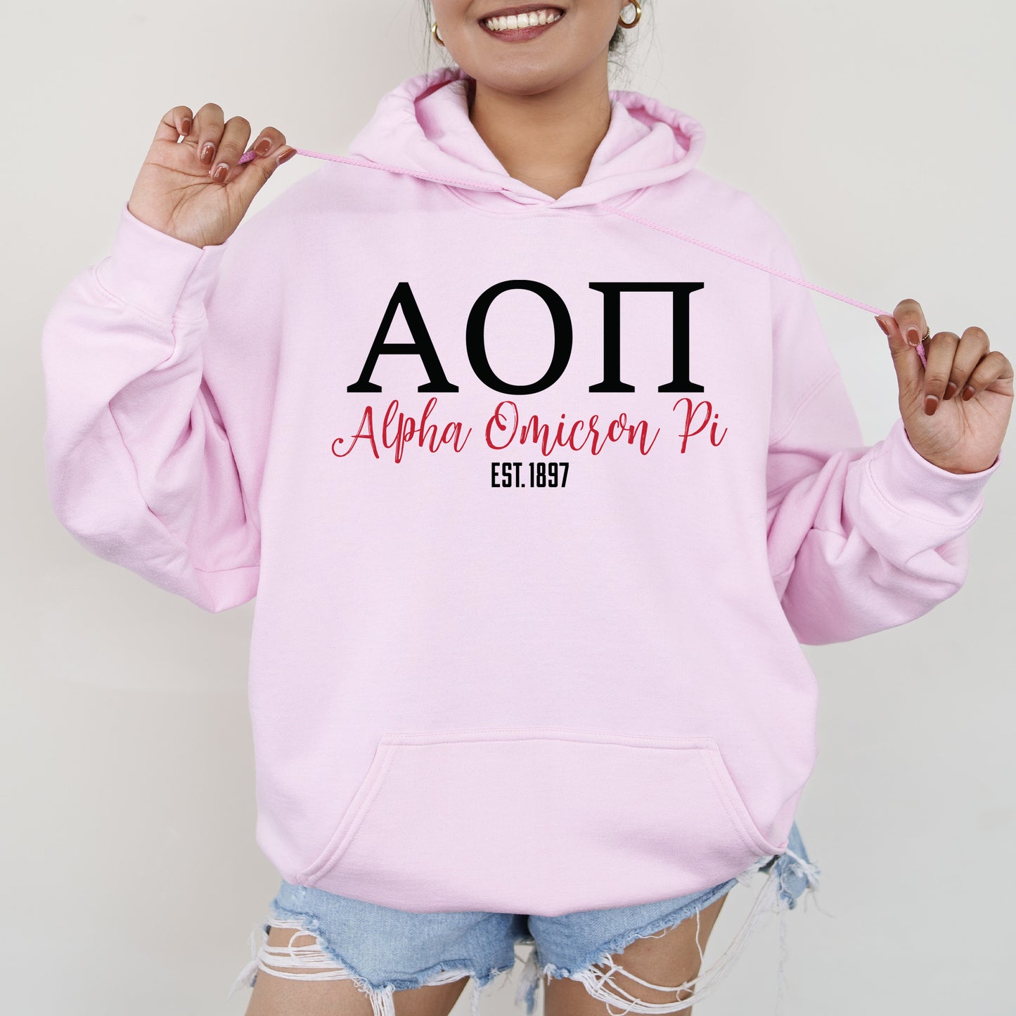 a woman wearing a pink hoodie with the word aoi on it