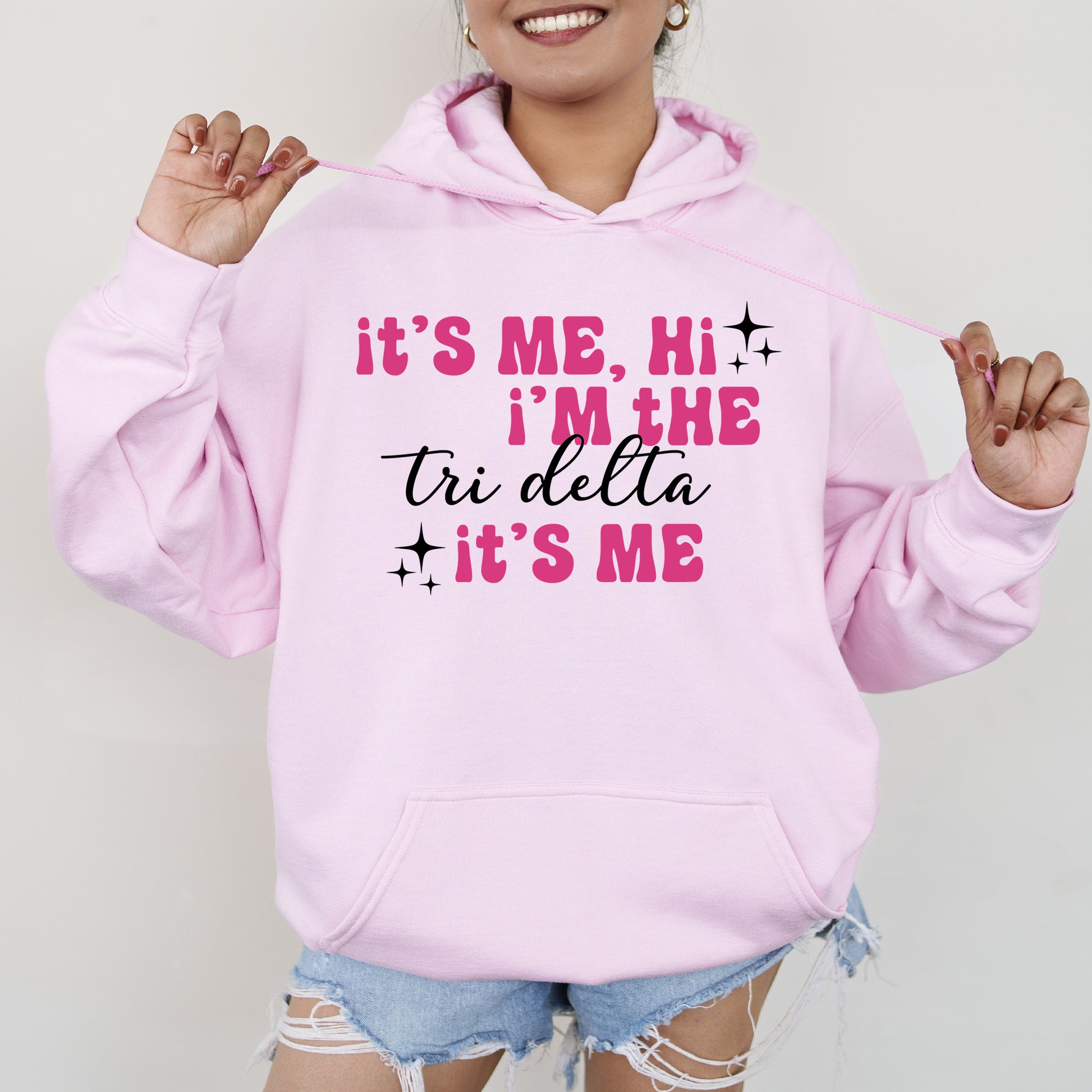 a woman wearing a pink hoodie that says it's me, i '