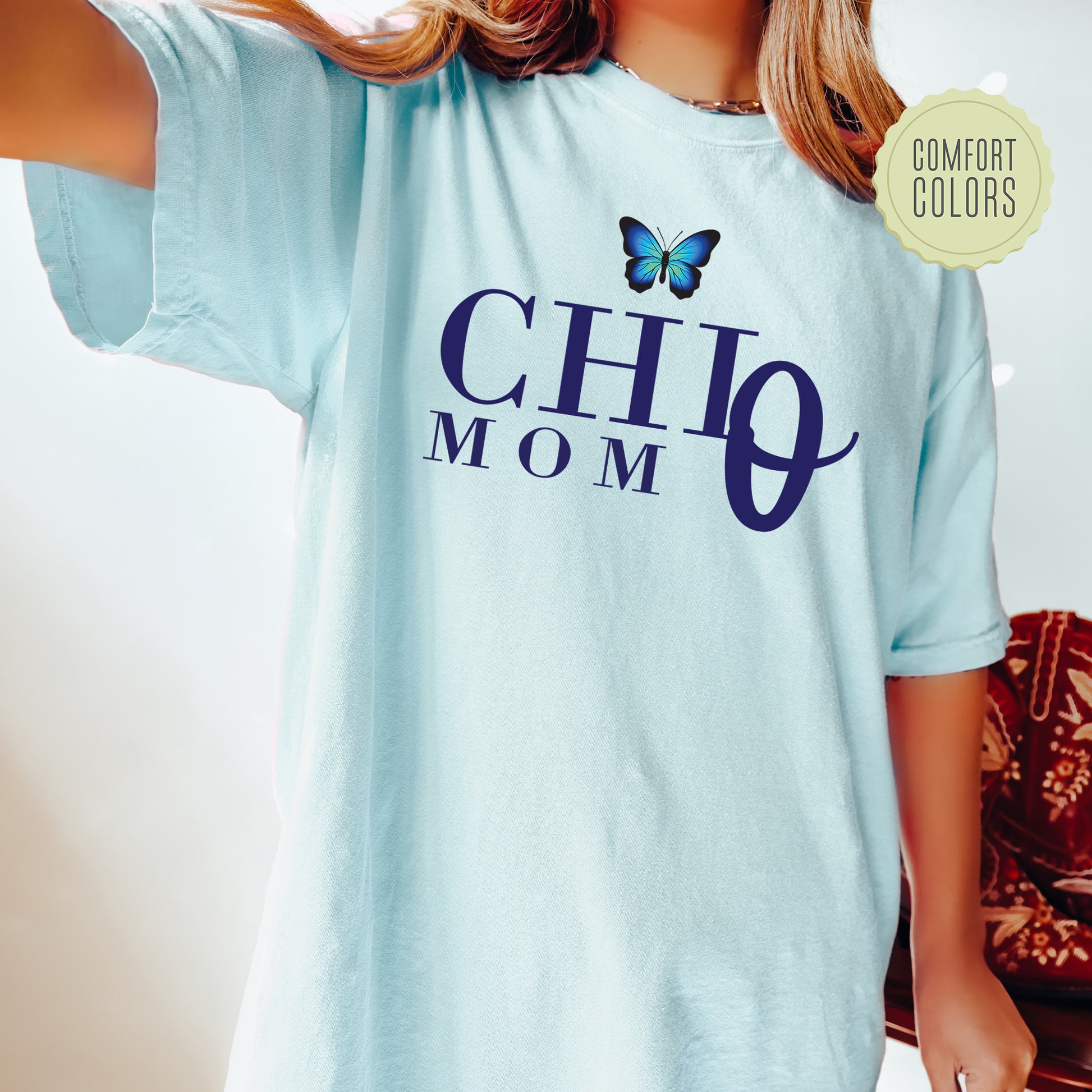 a woman wearing a blue shirt with a butterfly on it
