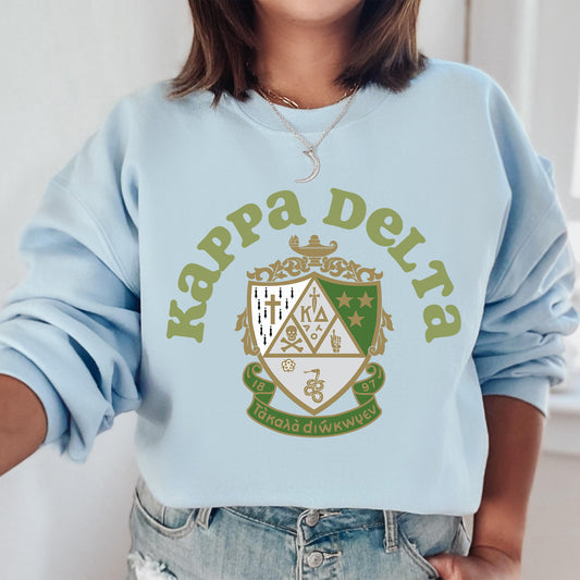 a woman wearing a light blue sweatshirt with a crest on it