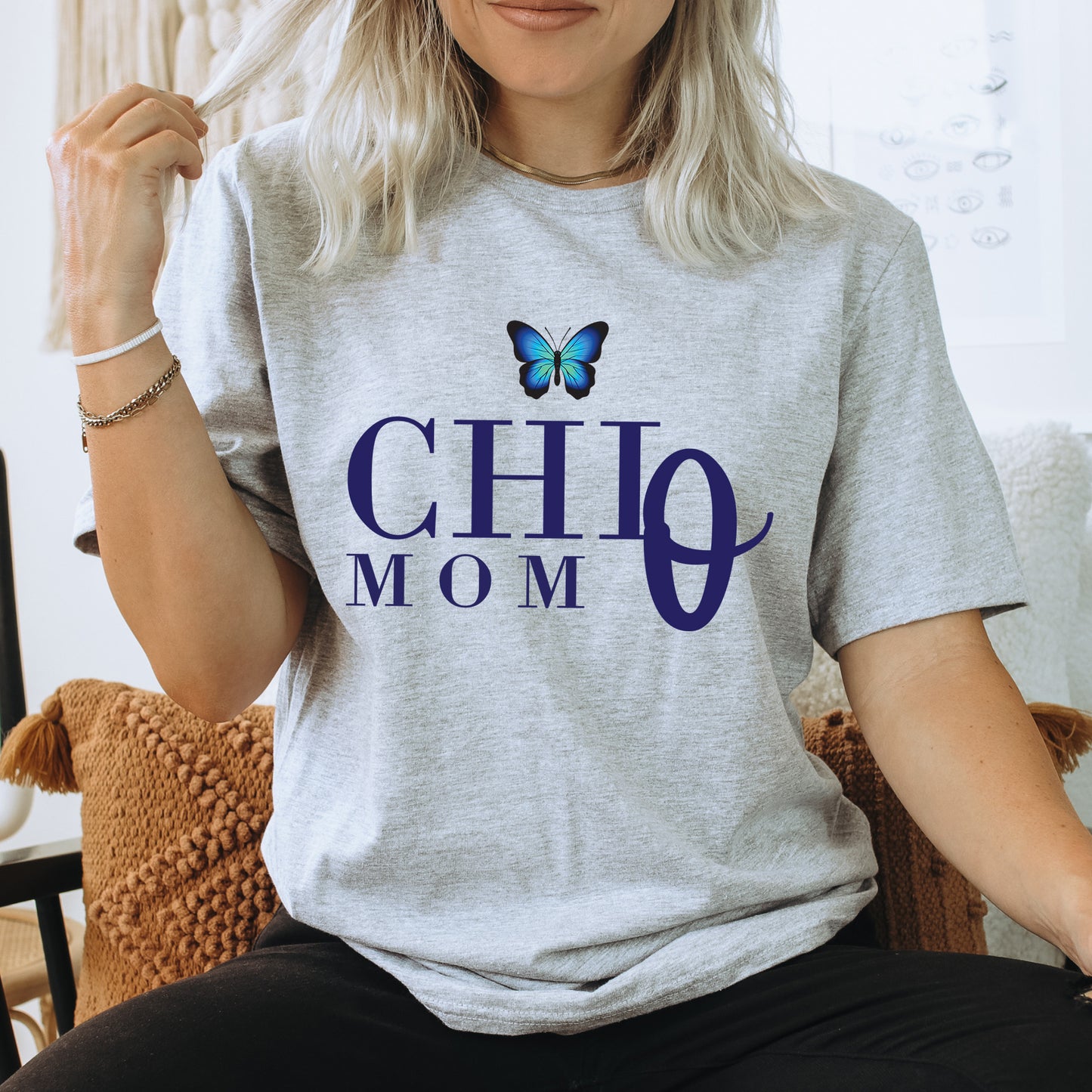 a woman sitting on a chair with a butterfly on her shirt