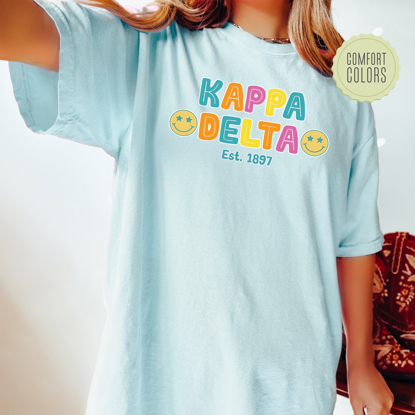 a woman wearing a blue kapa delta t - shirt