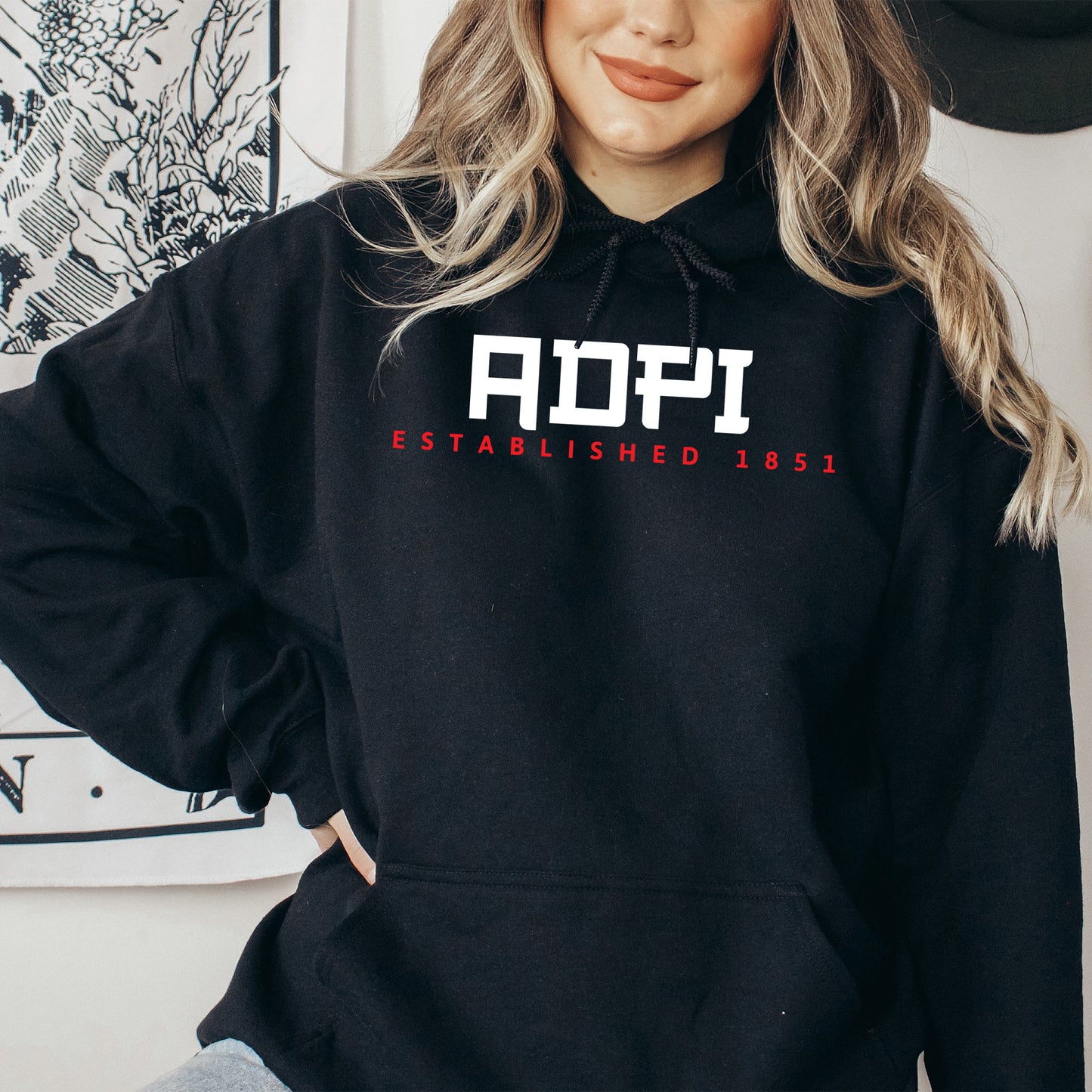 a woman wearing a black hoodie with the word adopt on it