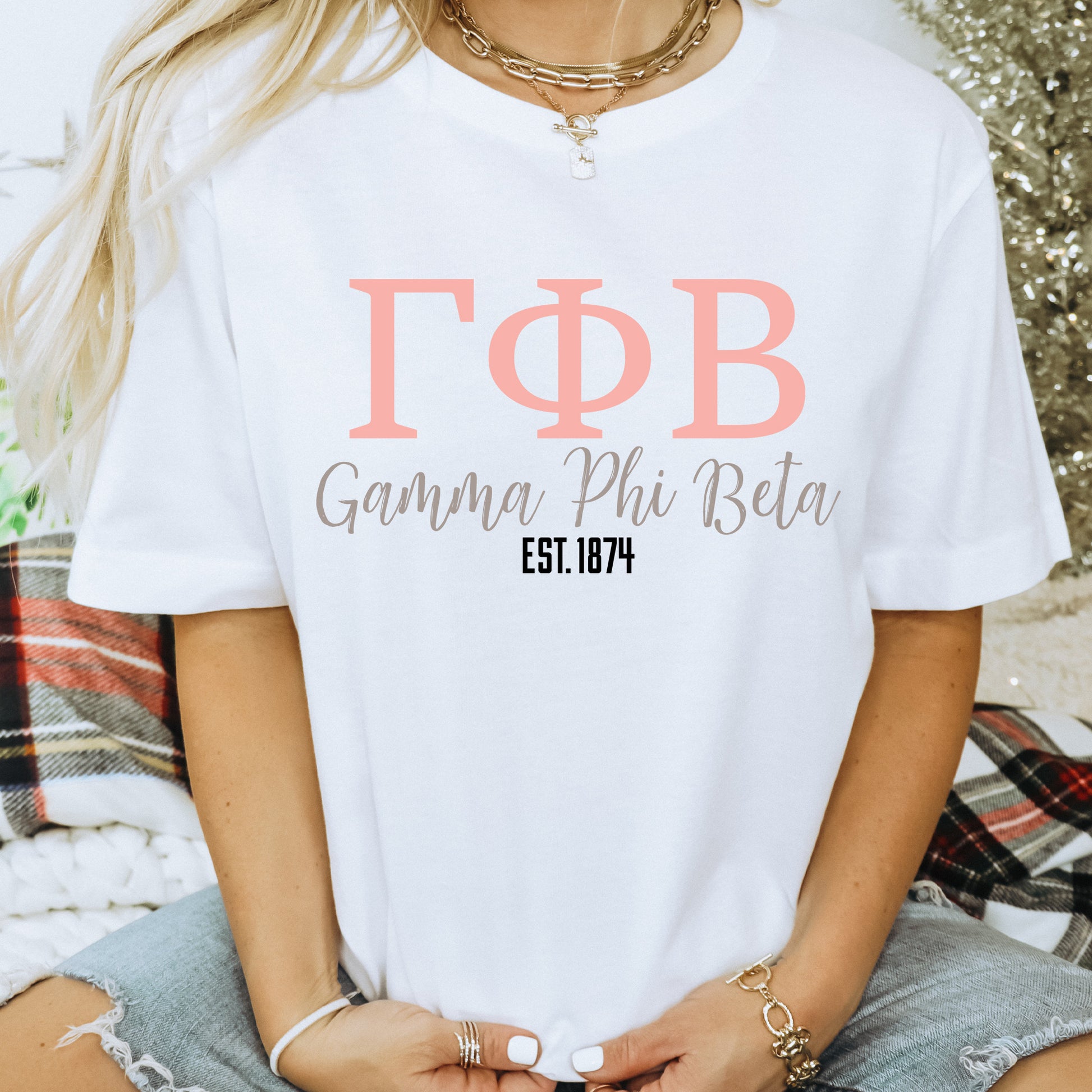 a woman wearing a white t - shirt with a greek alphabet on it