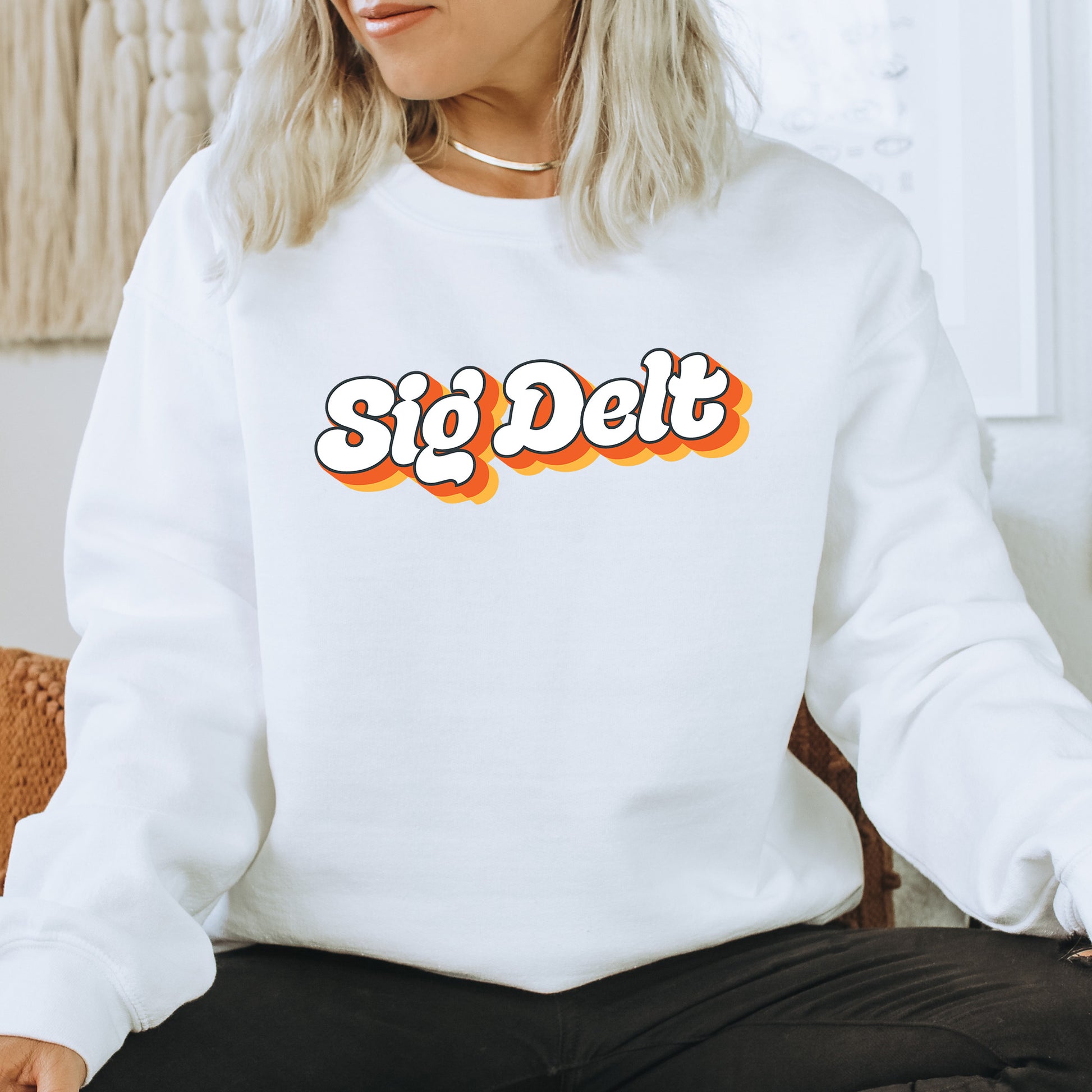 a woman sitting on a chair wearing a white sweatshirt with the word'sig