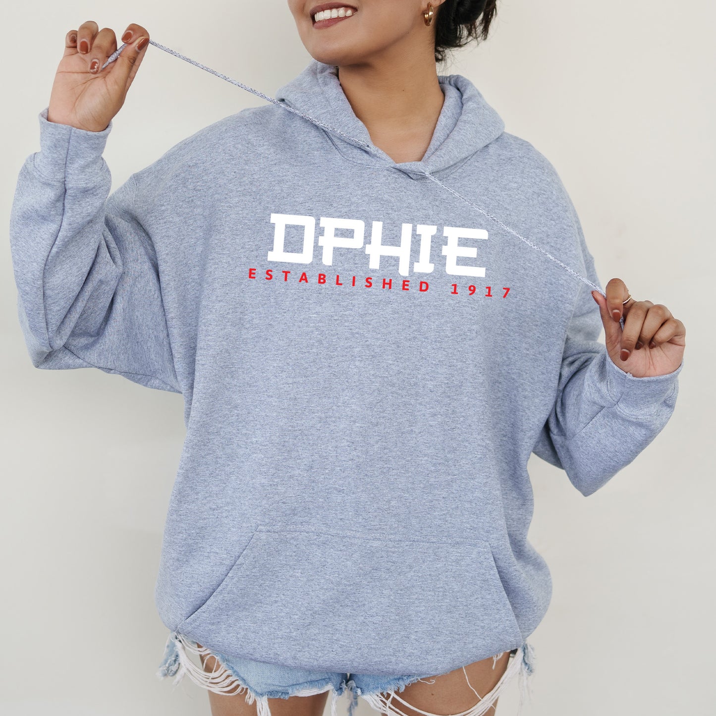 a woman in a blue hoodie holding a toothbrush