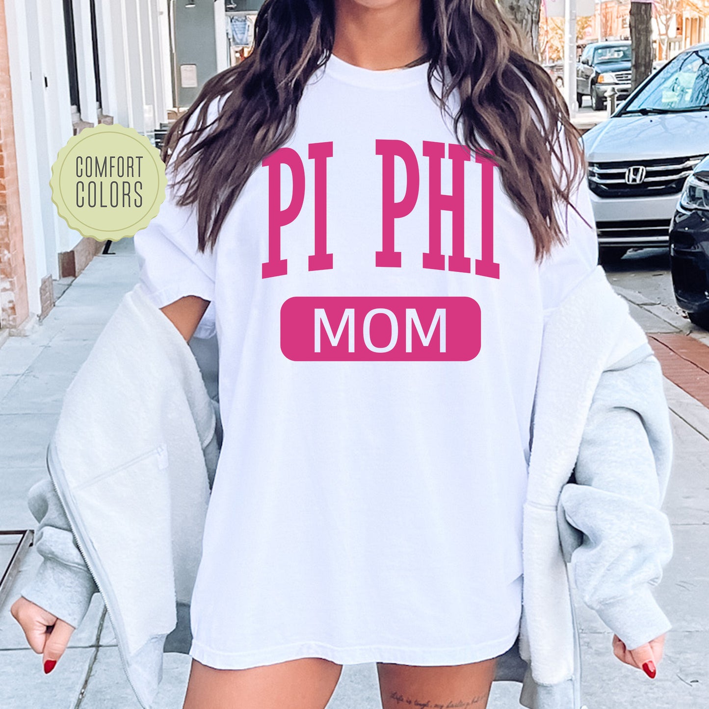 a woman wearing a white shirt that says pi phi mom