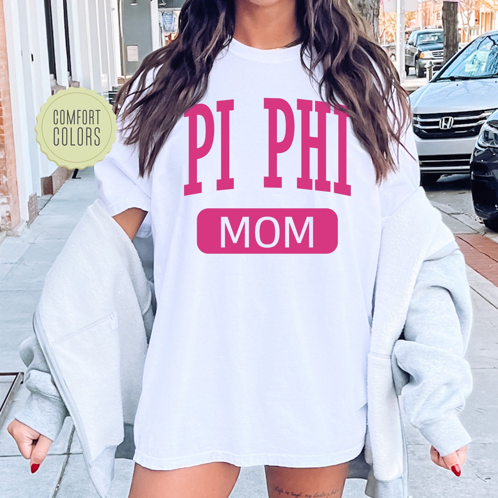 a woman wearing a white shirt that says pi phi mom