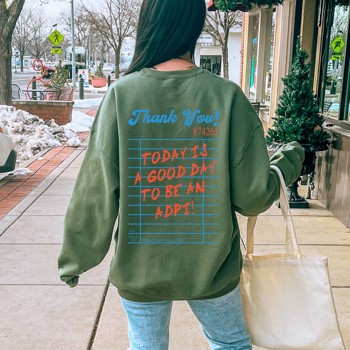 a woman walking down a sidewalk carrying a bag