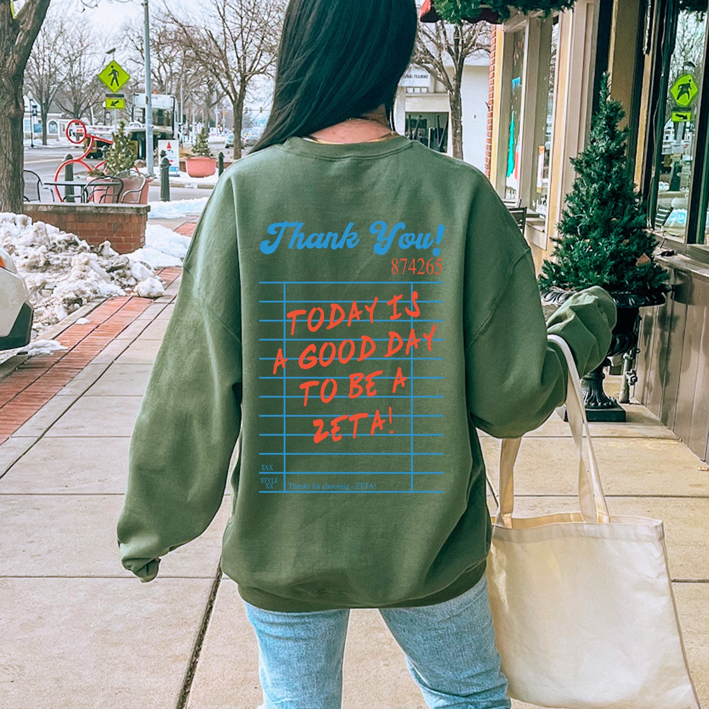 a woman walking down a sidewalk carrying a bag