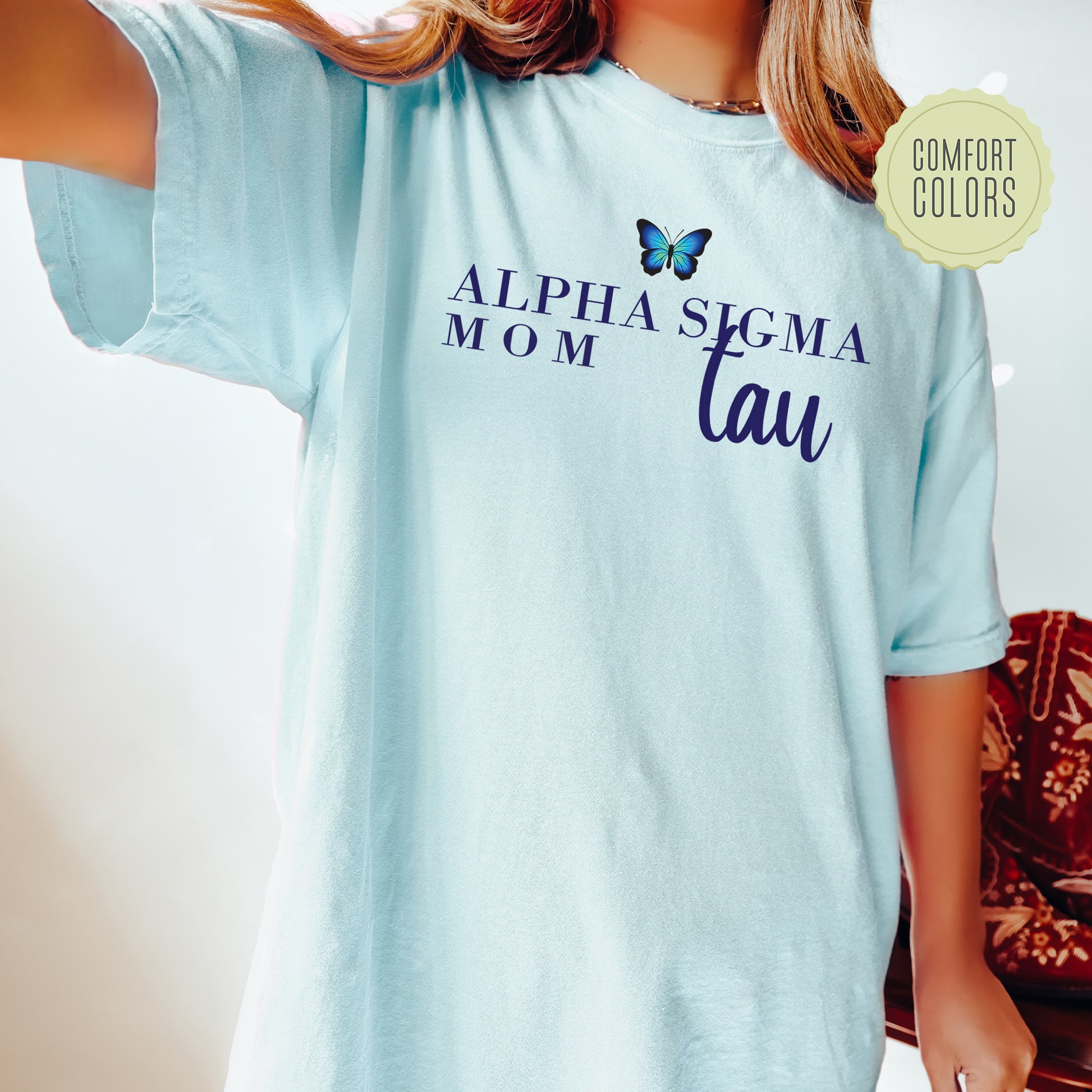 a woman wearing a light blue shirt with a butterfly on it